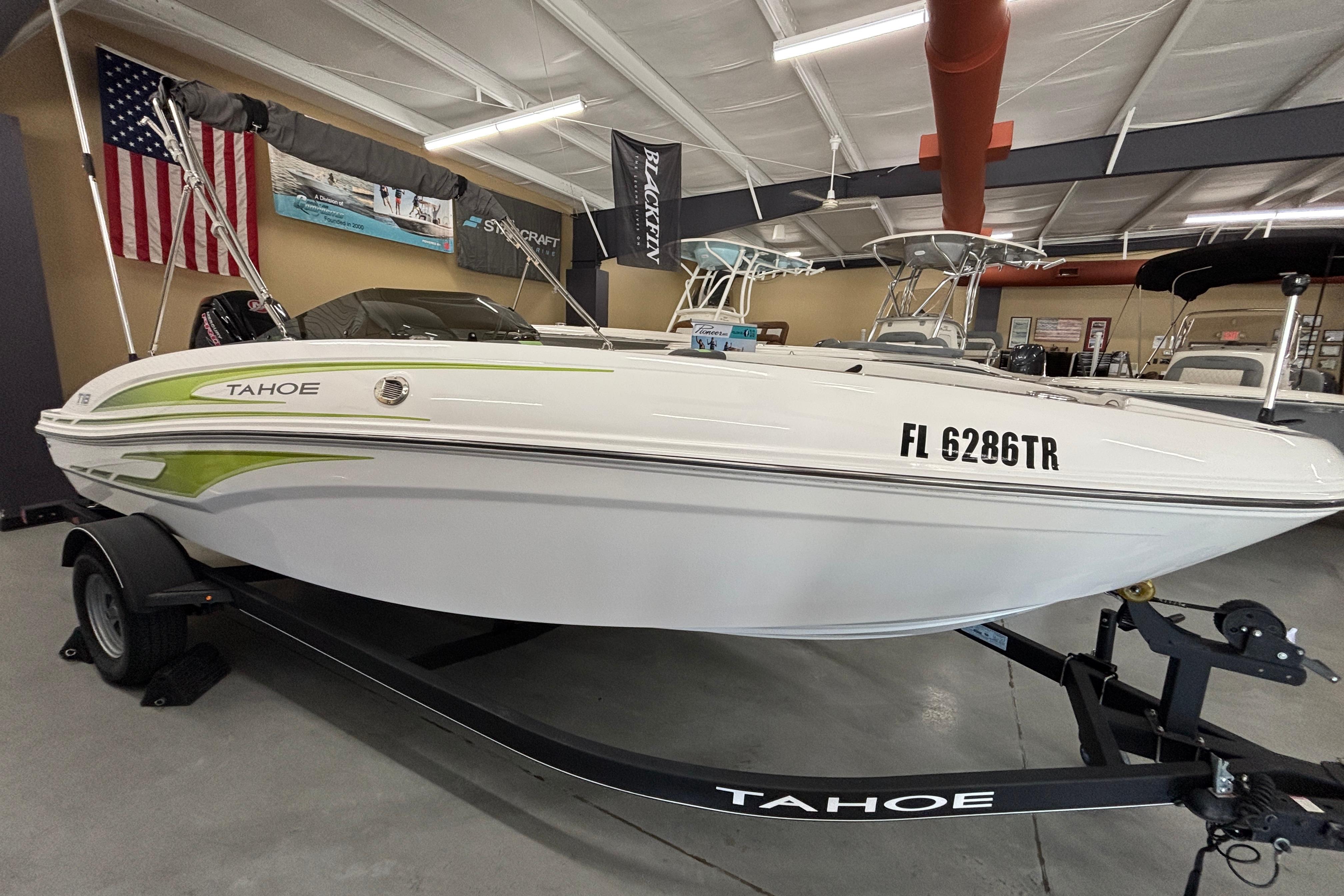 2024 Tahoe T18 boat on trailer in showroom, featuring sleek design and vibrant accents.