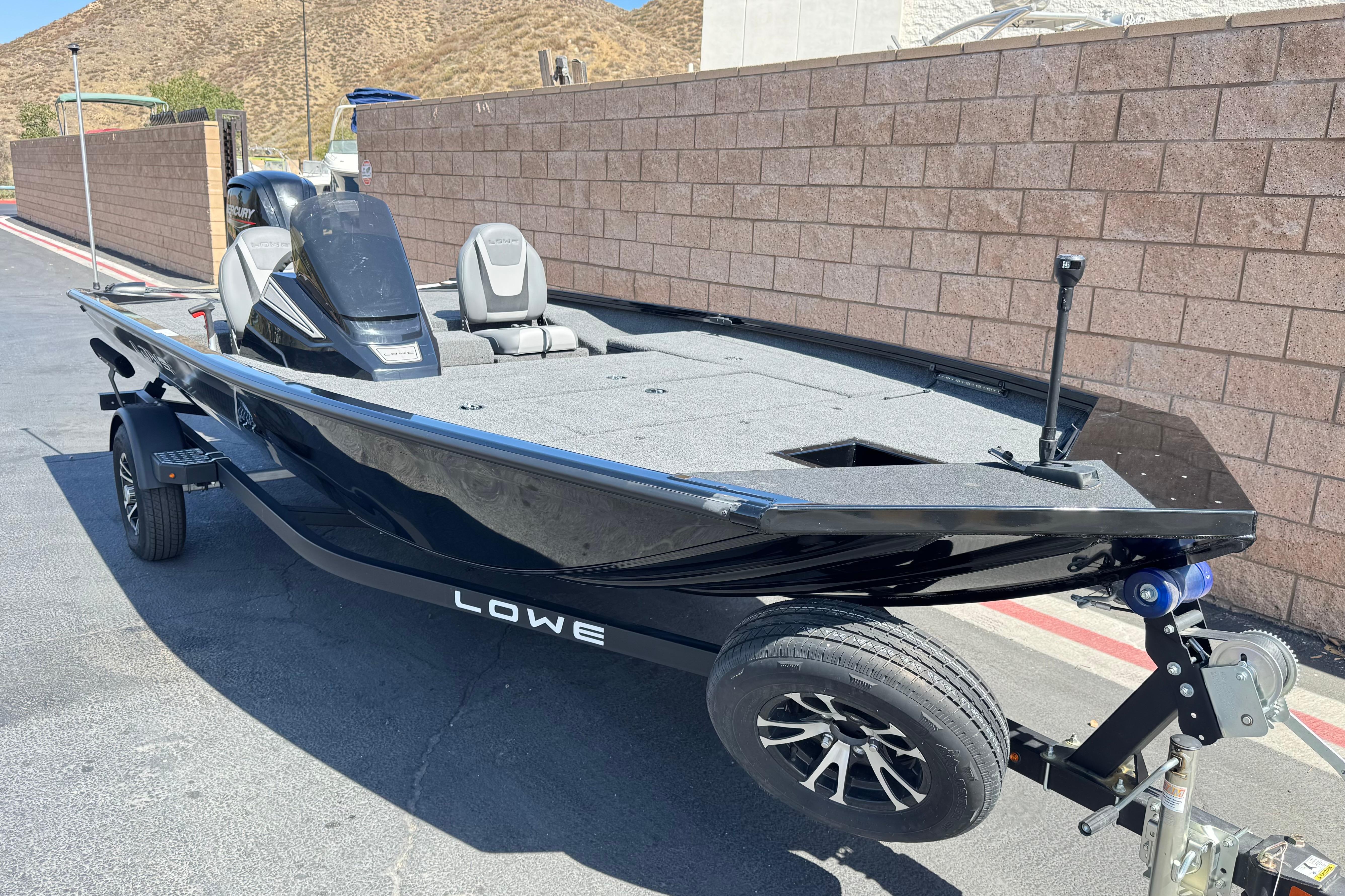 2024 Lowe Stinger 175 boat on trailer, parked outdoors, showcasing sleek design and modern features.