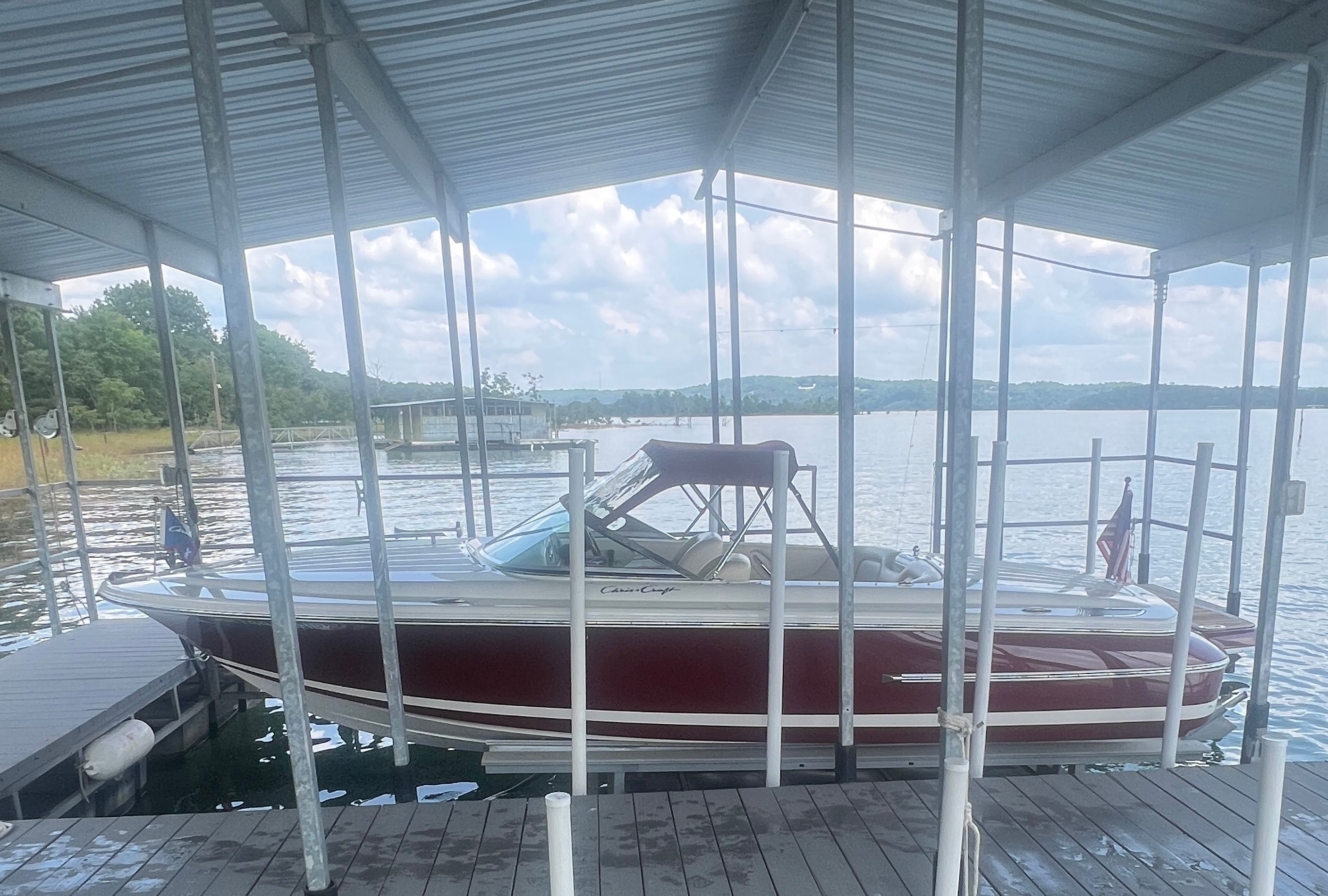 A 2006 Chris-Craft Speedster 20 docked in a covered boathouse on the water.