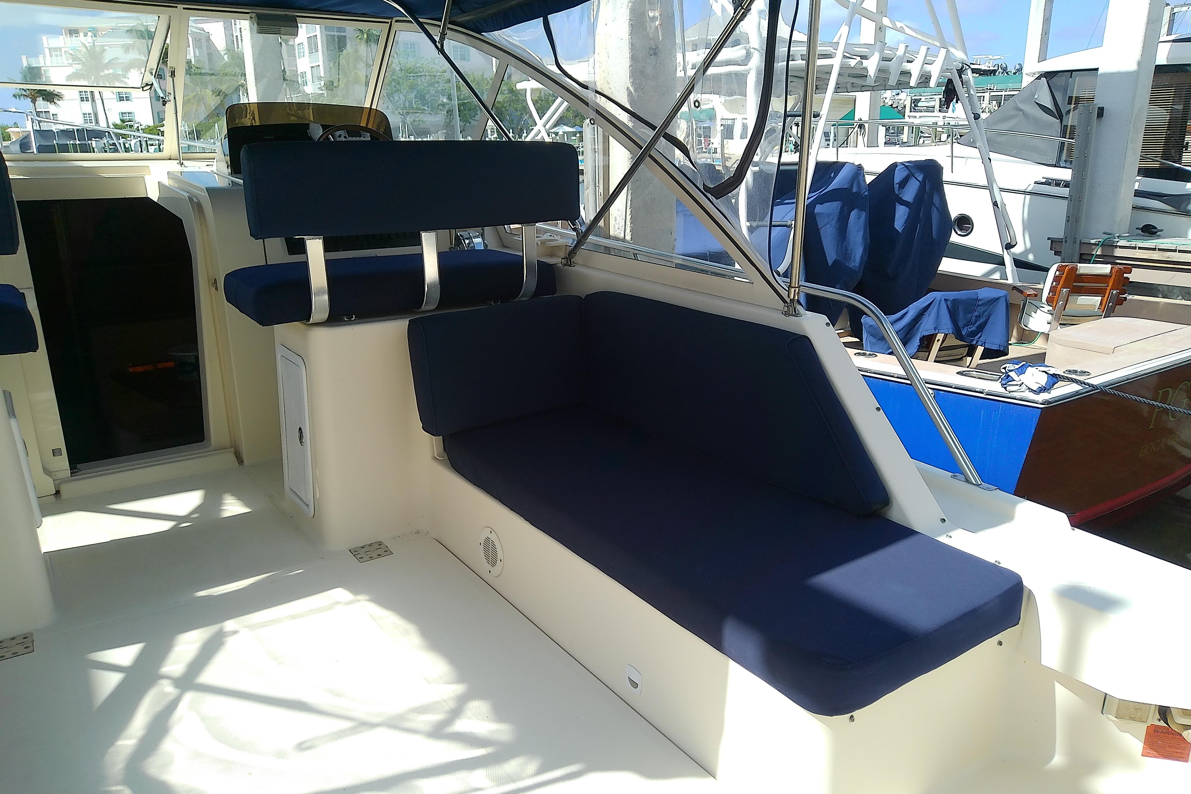 2004 Mainship 34 Pilot II boat interior with blue seating and open cockpit.