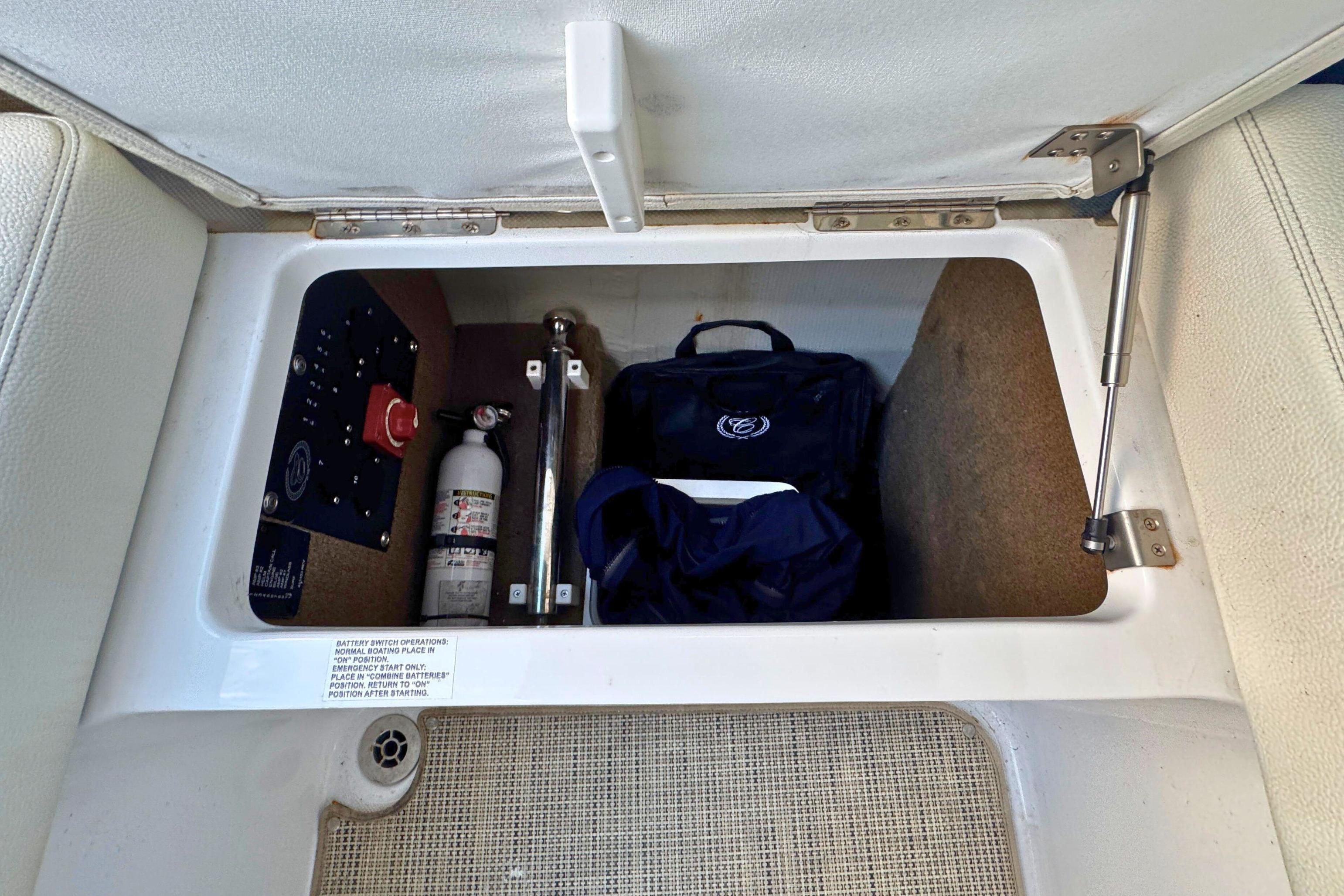 Storage compartment in a 2019 Cobalt R3 boat with safety equipment.