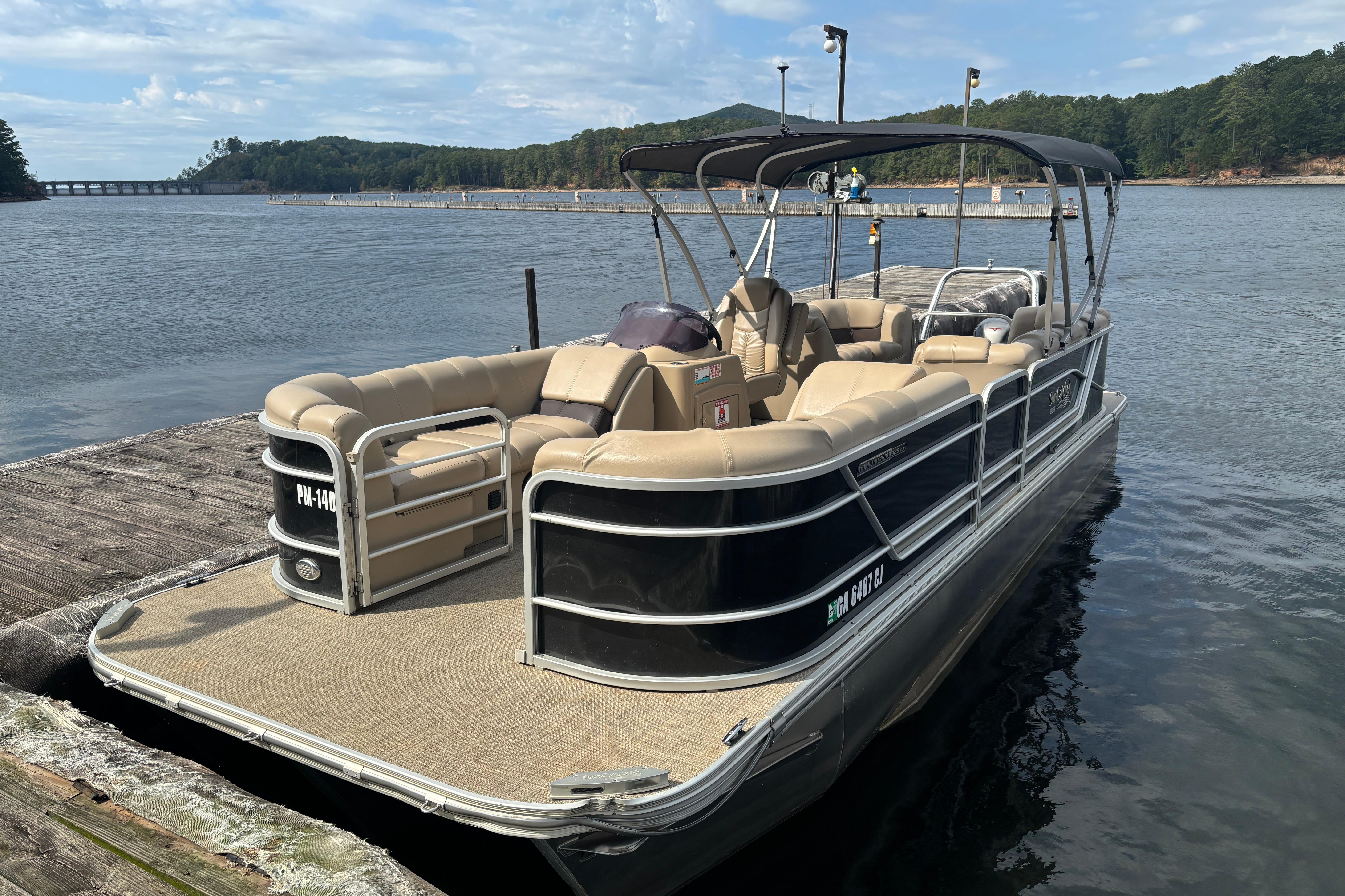 2021 SunCatcher Fusion 325RCX pontoon boat docked on a serene lake.