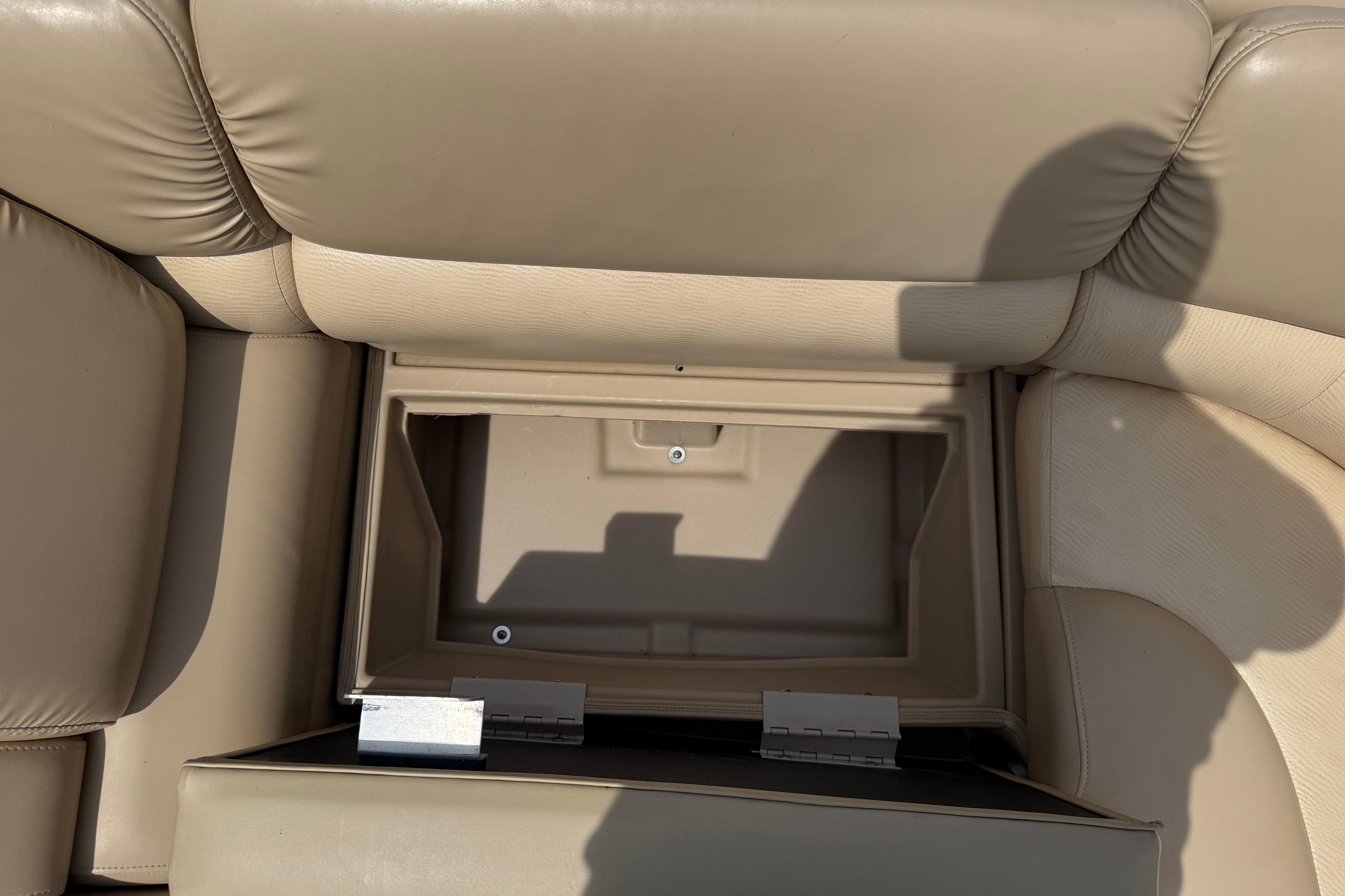 Open storage compartment in beige seating of 2011 Bennington 2575QCW I/O boat.