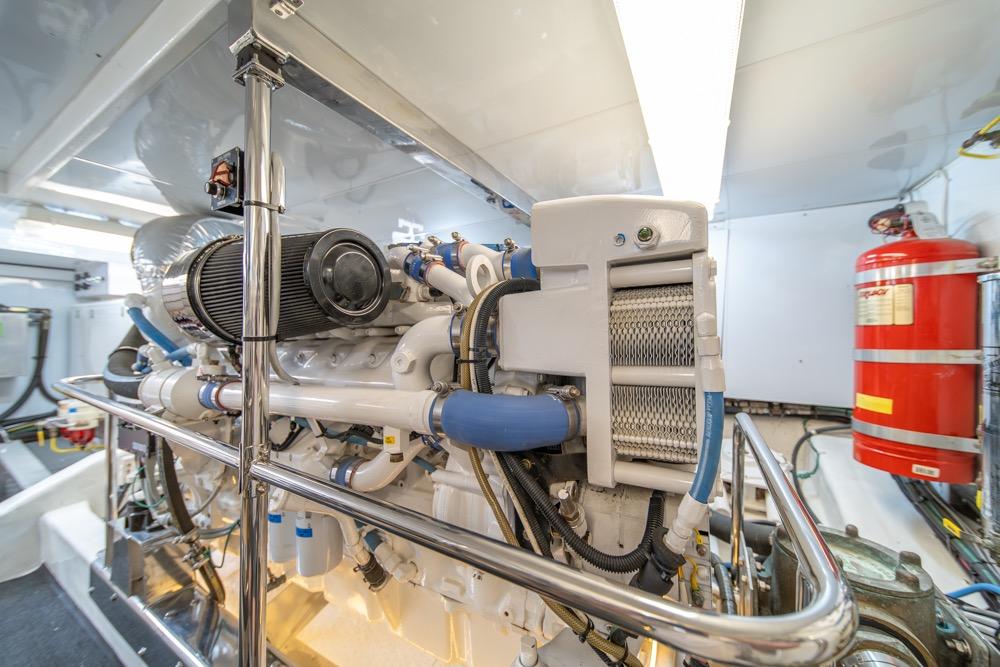 Engine room of 2005 Ocean Alexander 64 Motoryacht, featuring mechanical components and fire extinguisher.