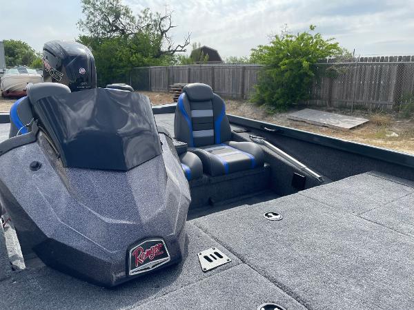 2025 Ranger RT188P boat interior with seating and console, outdoors near a wooden fence.