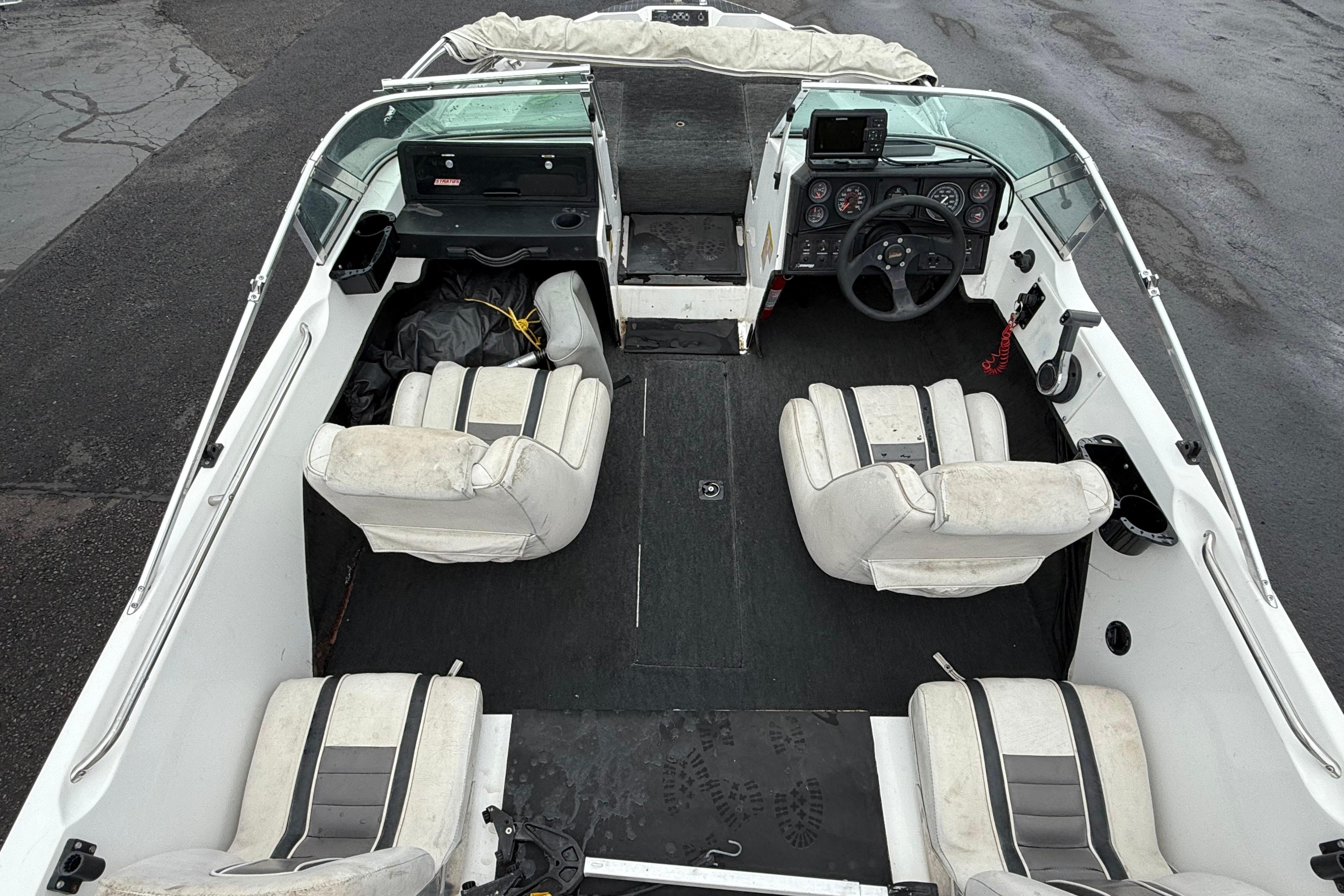 Interior of a 1996 Stratos 283 FS boat with white seating and steering console.