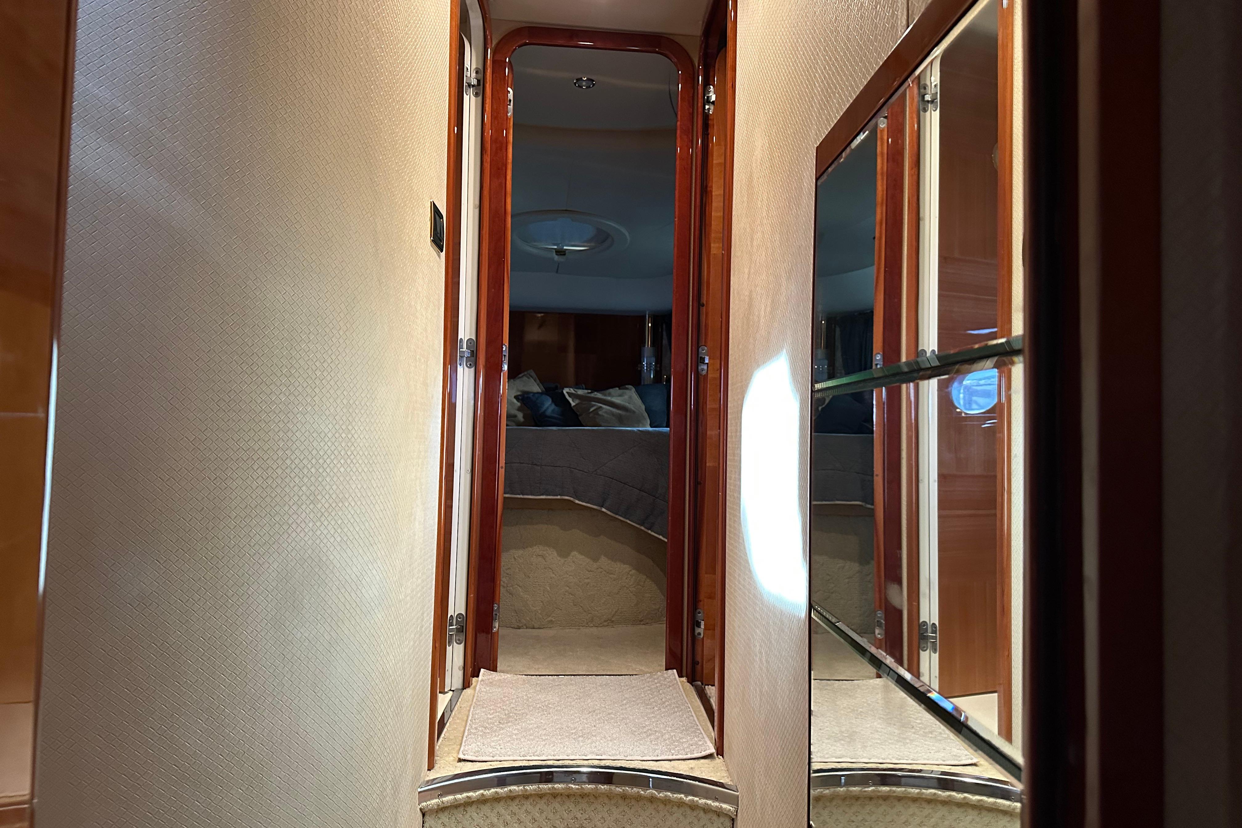 Interior hallway of a 2004 Azimut 55E yacht, featuring wood accents and a mirrored wall.