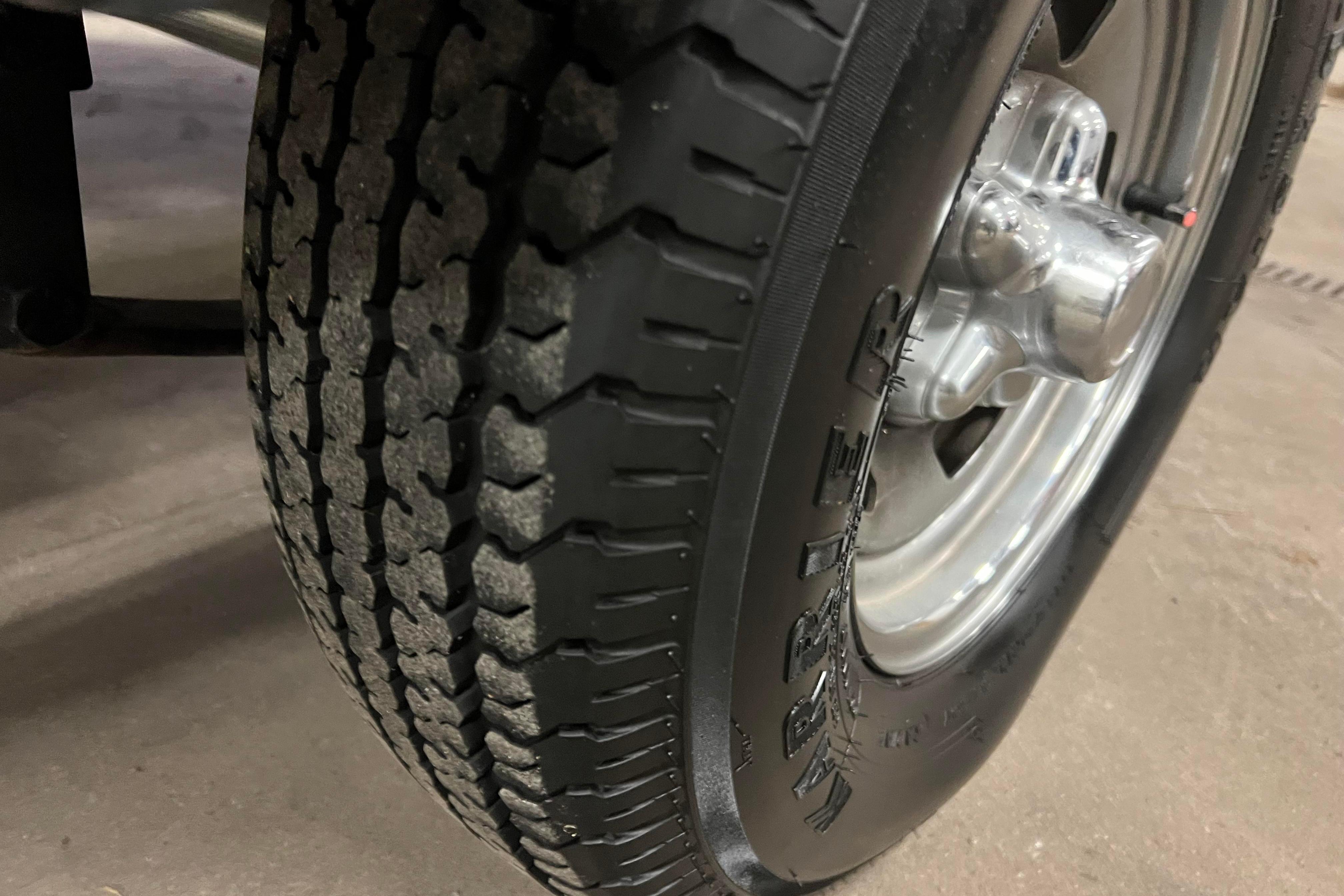 Close-up of a 2022 Tracker Pro Guide V-16 WT trailer tire and wheel.