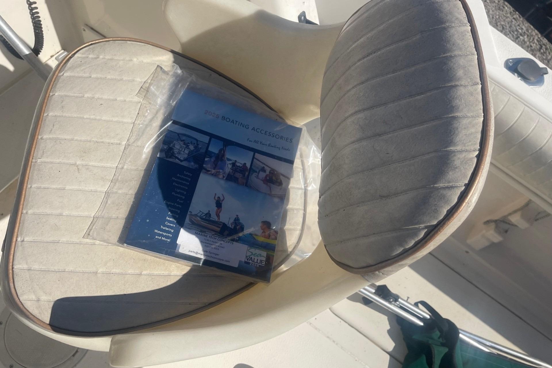 Boat seat with a 2023 boating accessories catalog on a Seamaster 2388 WA, 2000 model.