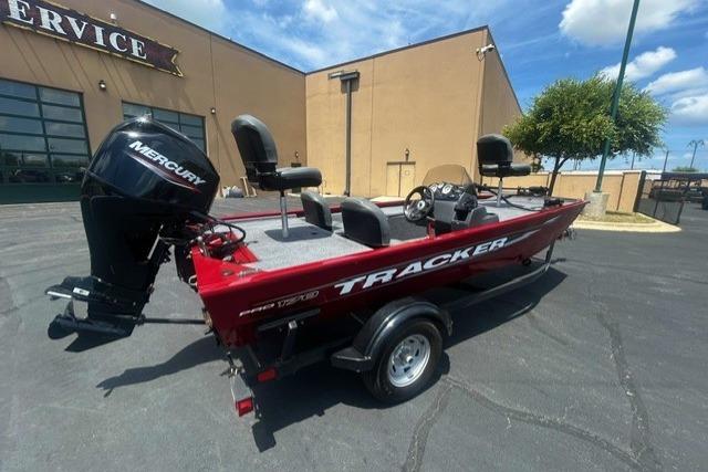 2026 Tracker Pro 170 boat with Mercury engine, parked outdoors near a service building.
