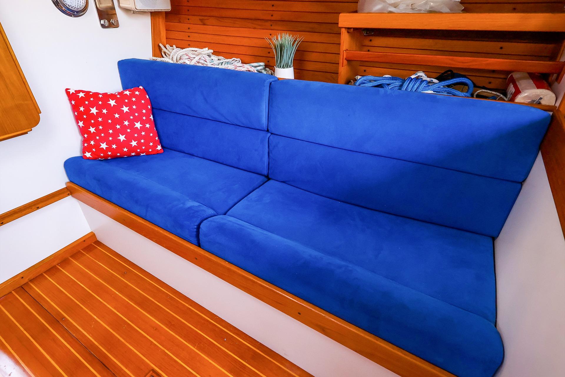 Blue cushioned seating with red star pillow in 2001 J Boats J/32 interior.