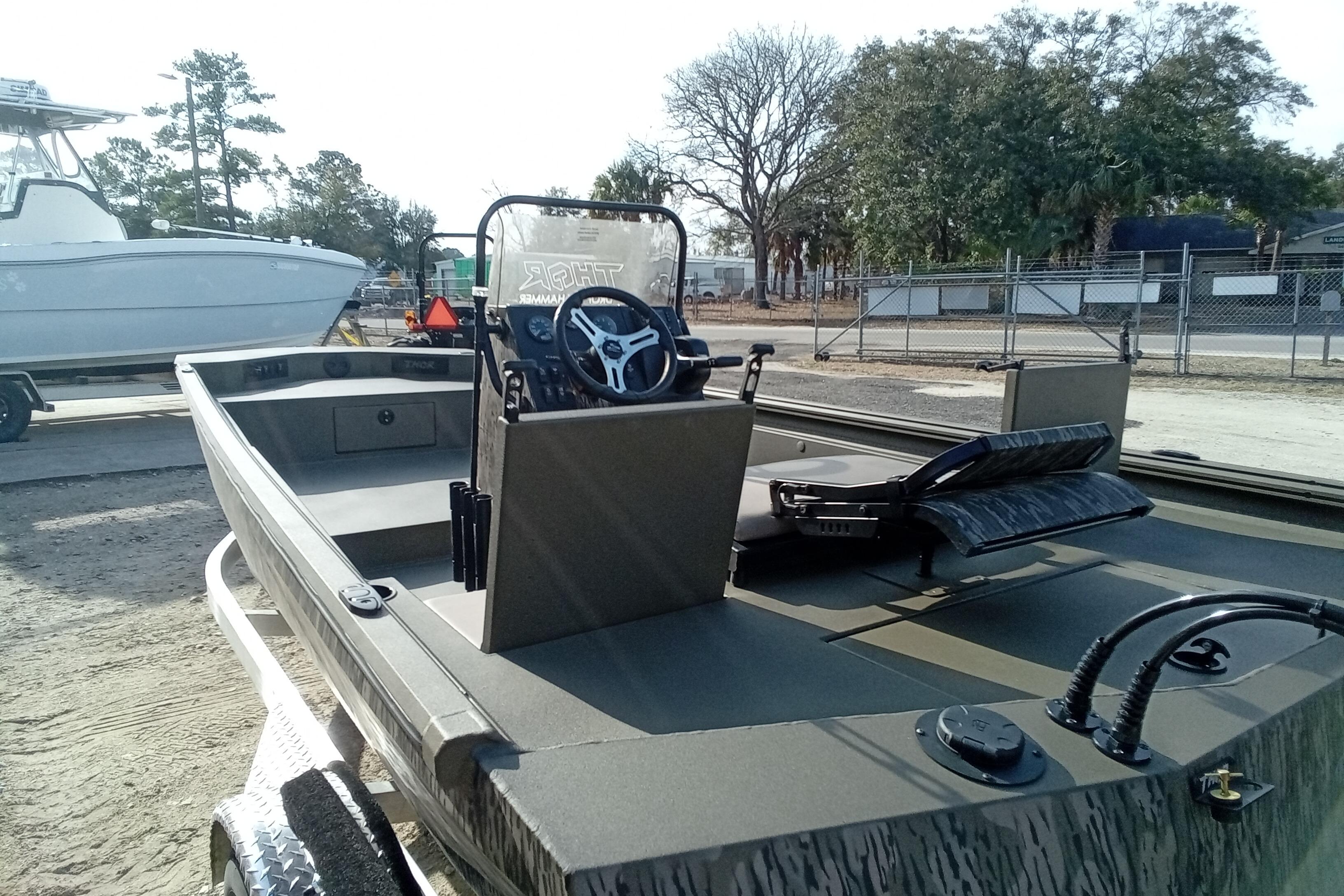 2026 Thor 1900 Low Country Elite boat with steering console, parked outdoors.