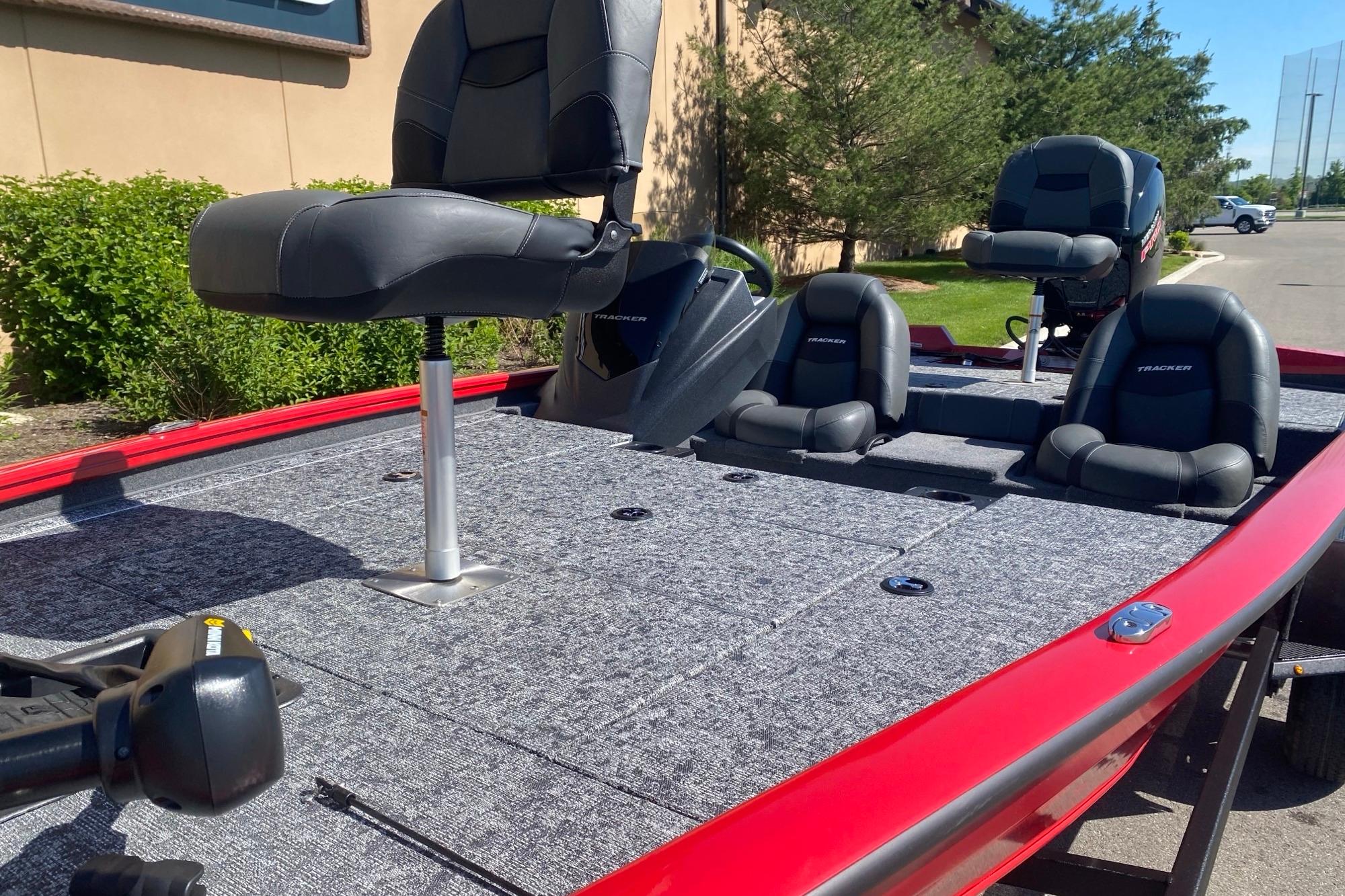 2026 Tracker Pro Team 195 boat with gray seating and red exterior, parked outdoors.