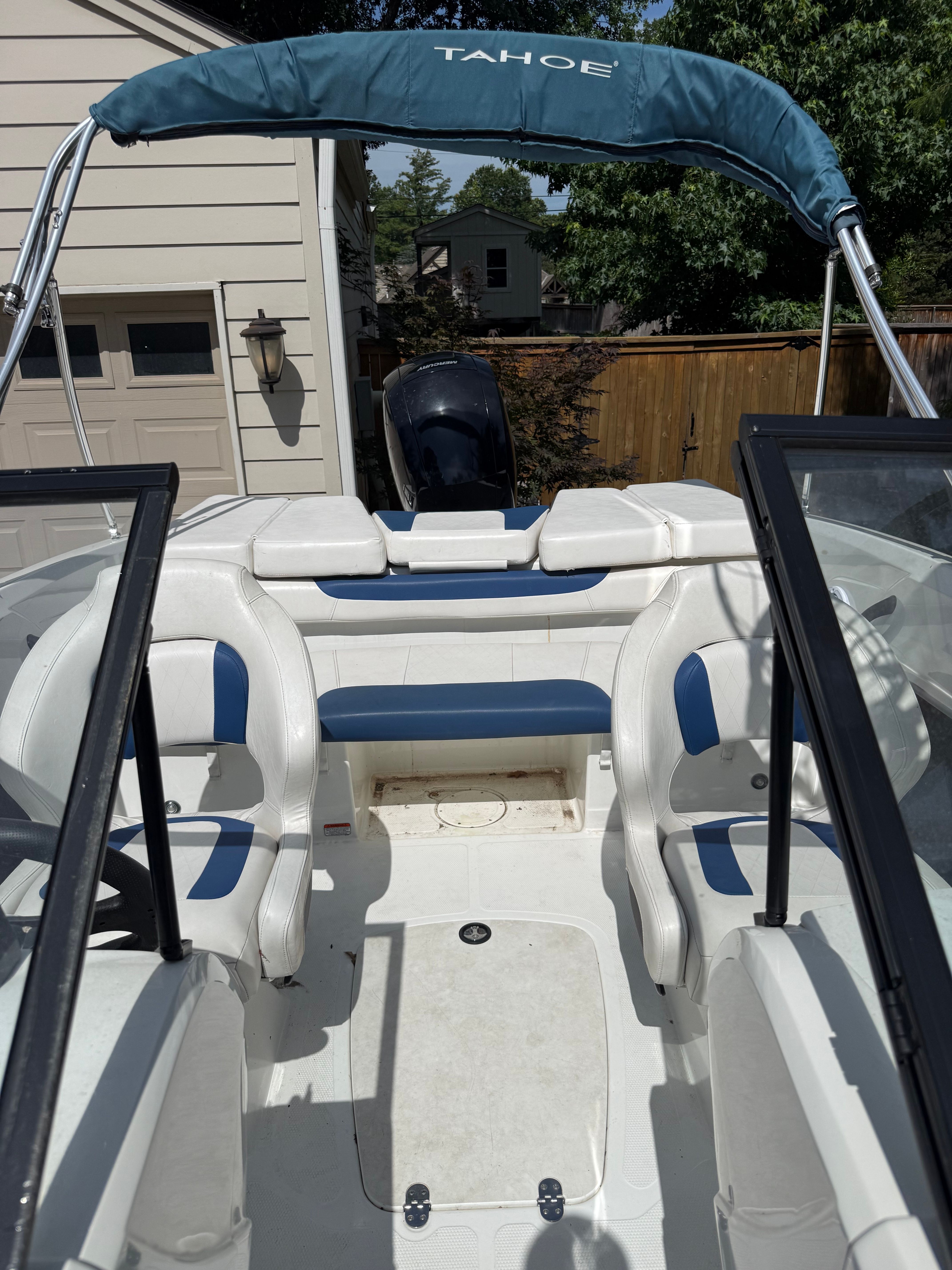 The image shows the cockpit of a 2019 Tahoe 450 TF boat with blue and white seating.