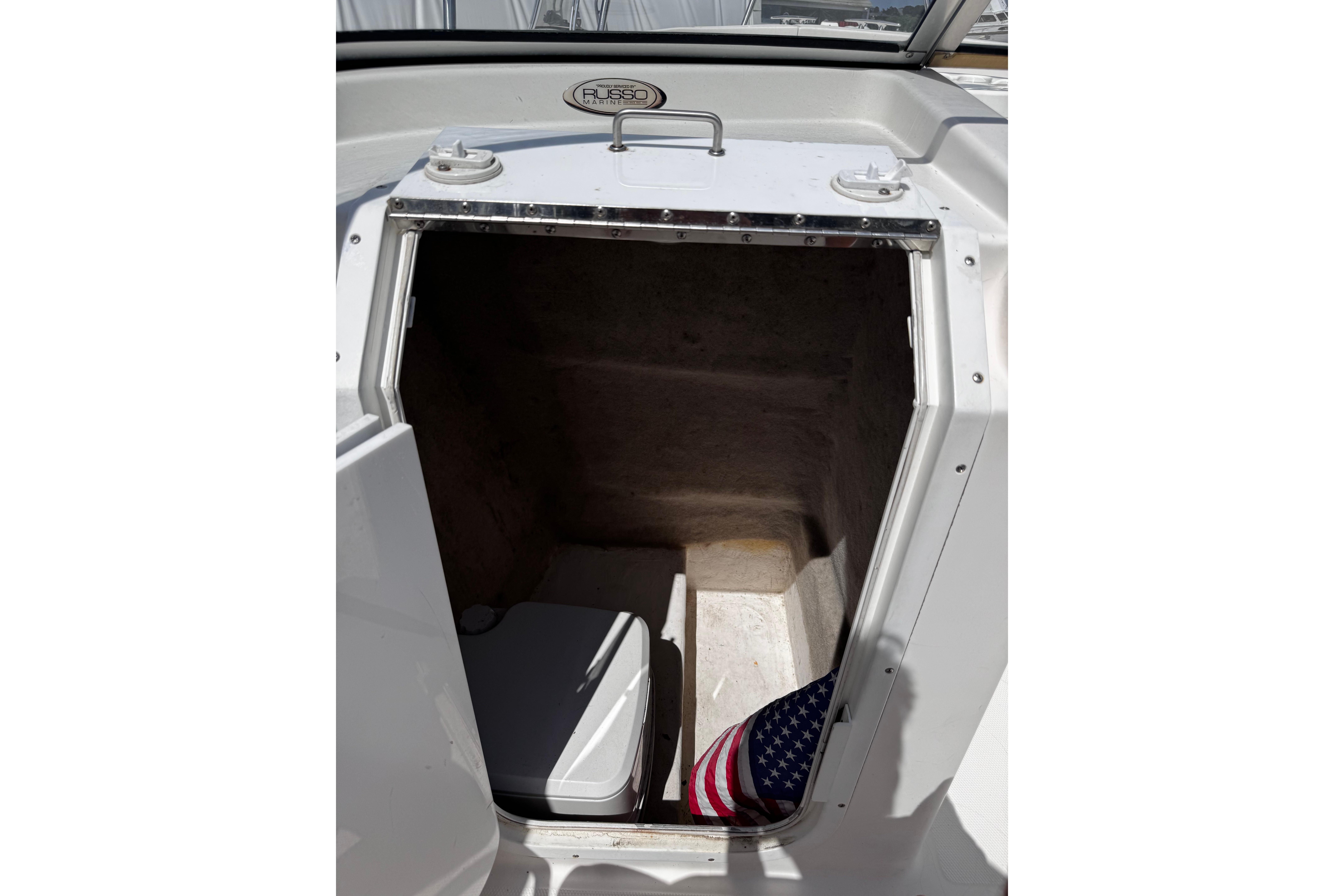 2003 Palm Beach 2200 Dual Console boat storage compartment with American flag and cooler.