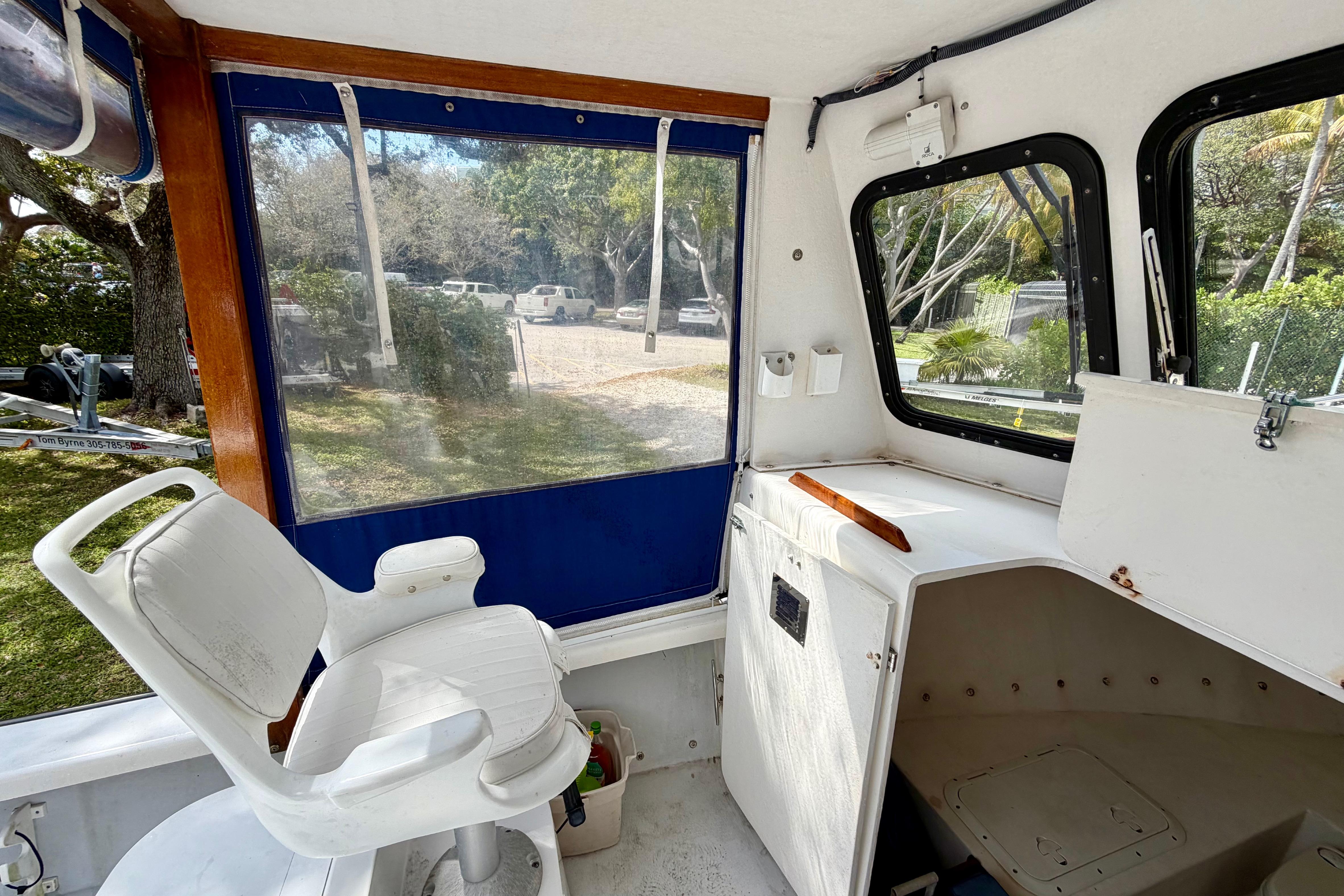 Interior of a 2000 Eastern 22 Lobster Fisherman boat with white seating and windows.