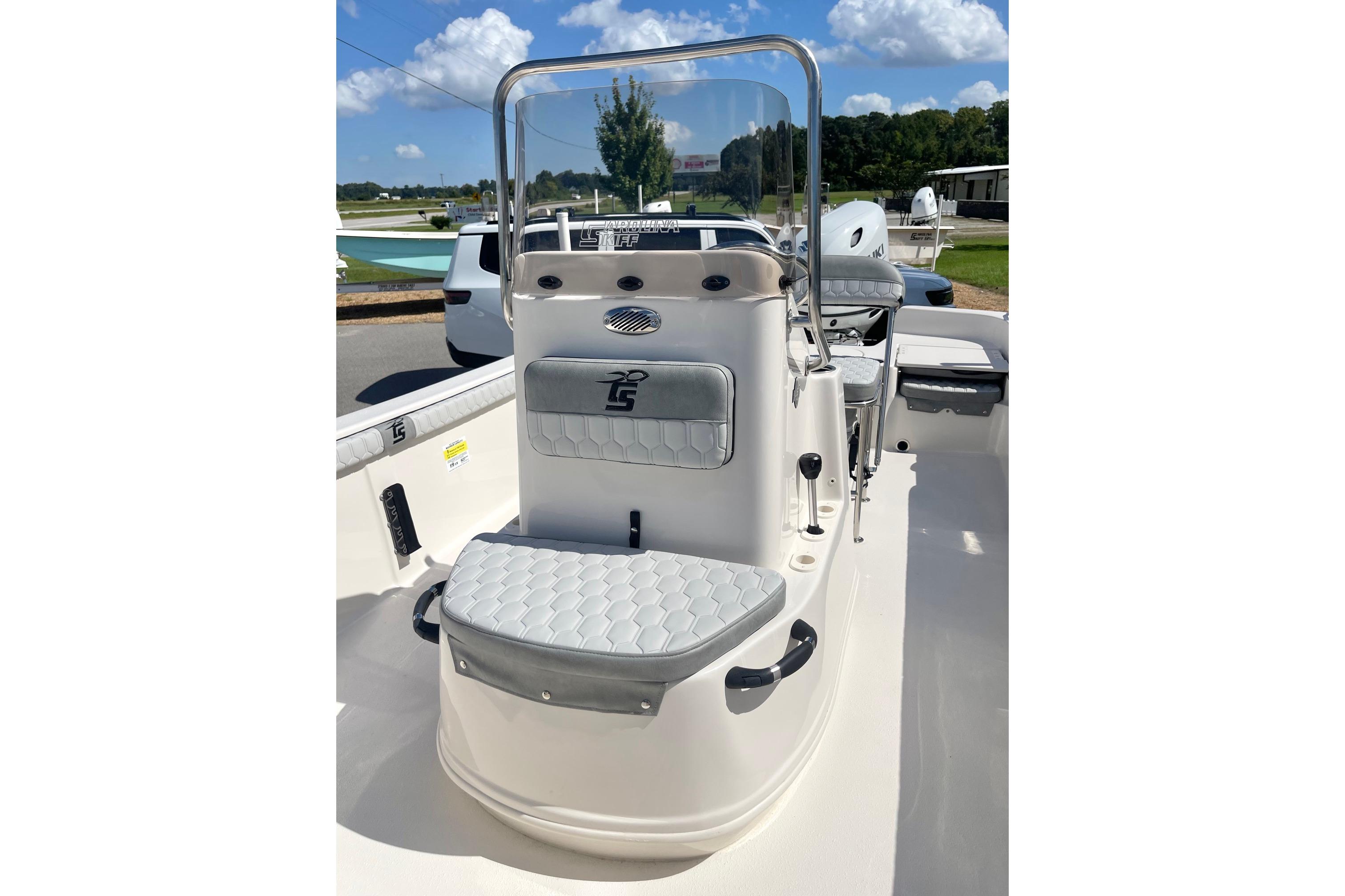 2026 Carolina Skiff 19 LS boat interior with seating and console, under a clear blue sky.