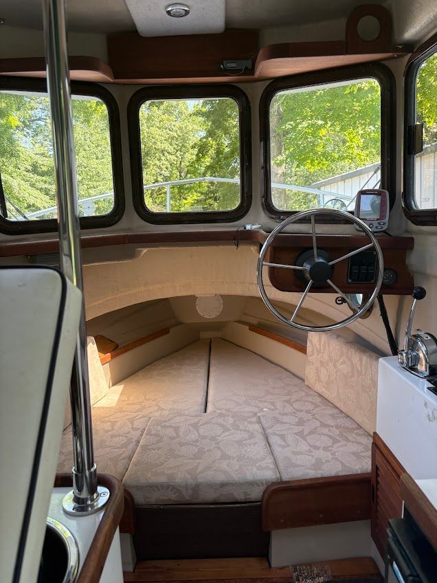 Interior of a 2007 Ranger Tugs R-21 EC with cozy seating and steering wheel.