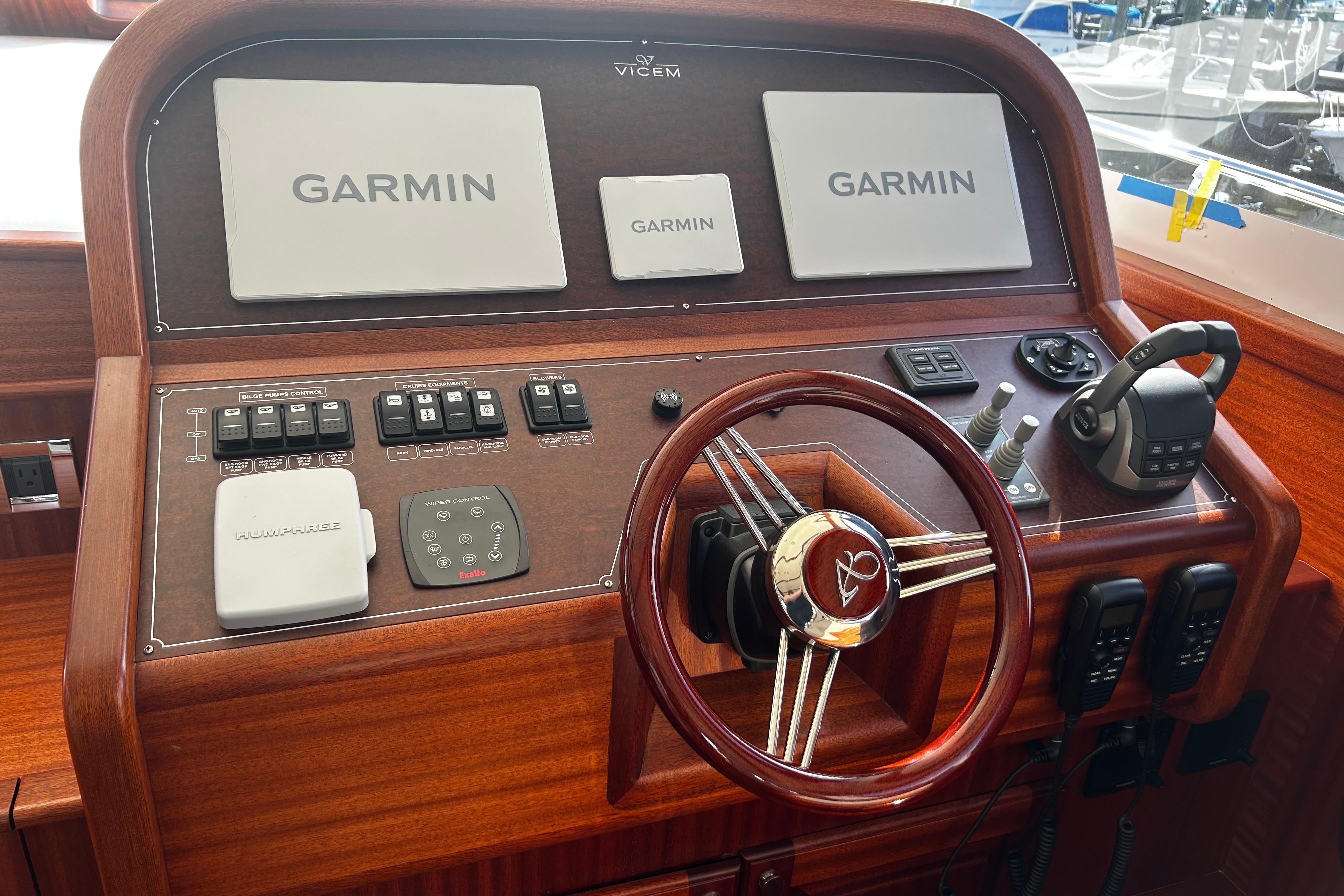 2026 Vicem 55 Classic yacht helm with Garmin navigation and wooden steering wheel.