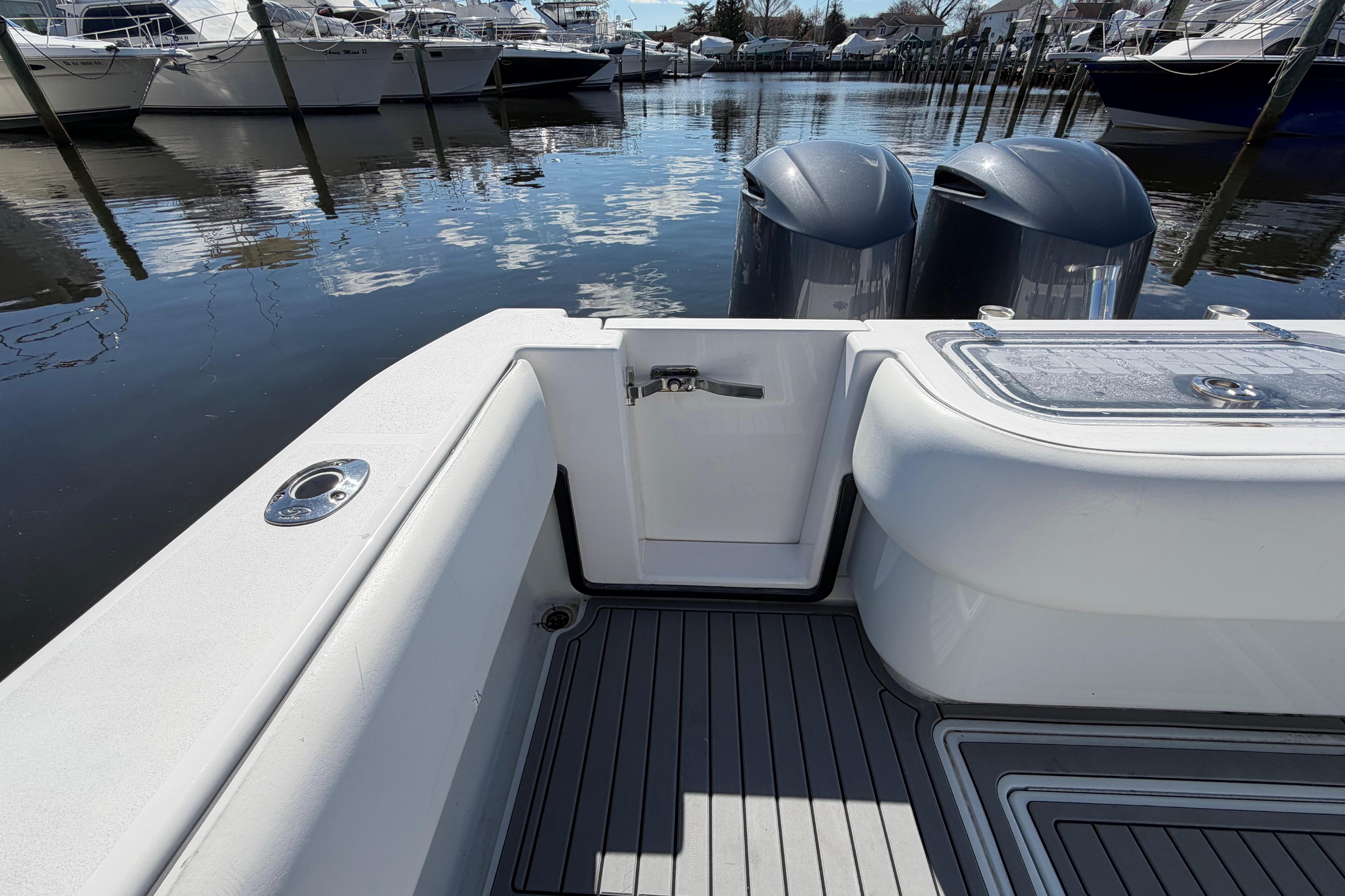 2015 Contender 32 ST boat with dual engines docked in a marina.