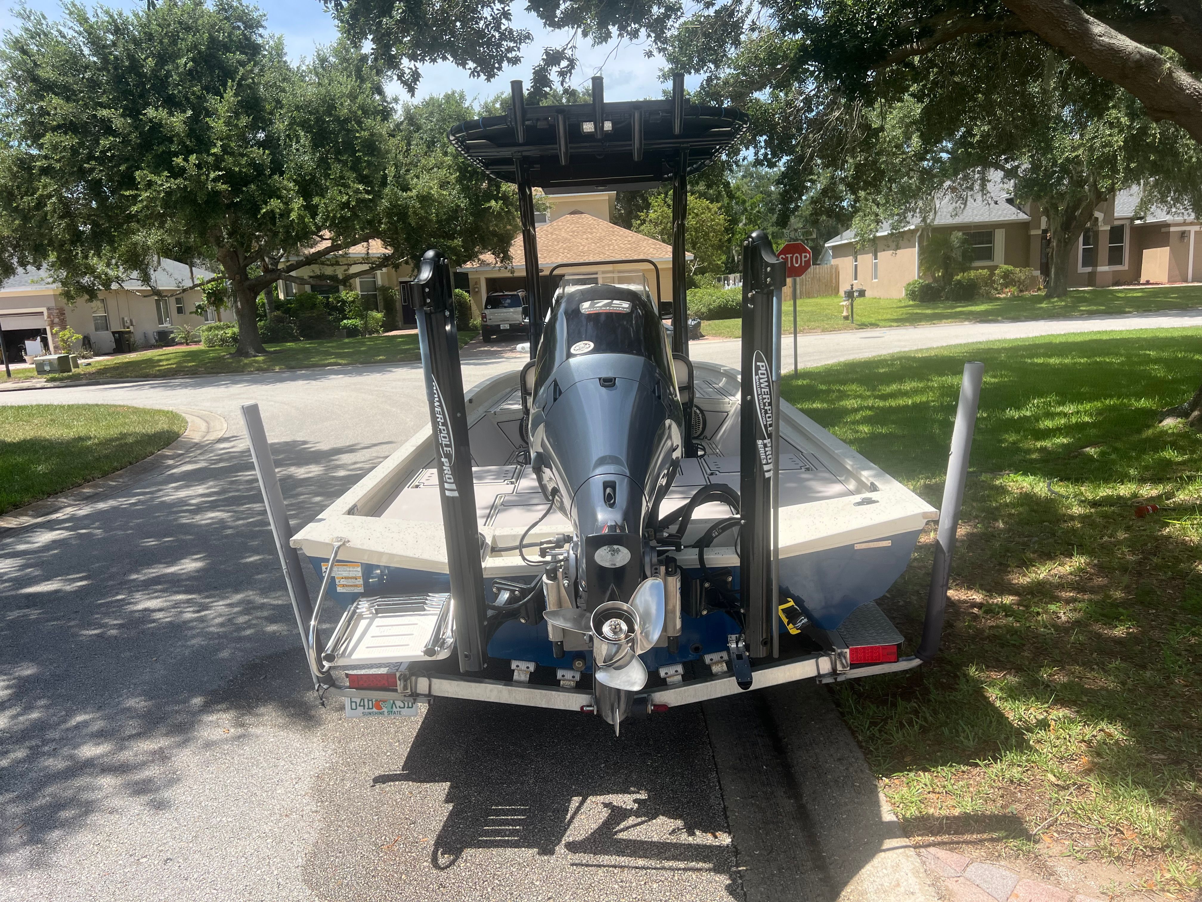 2016 Xpress H24B Bay boat on trailer in residential area.