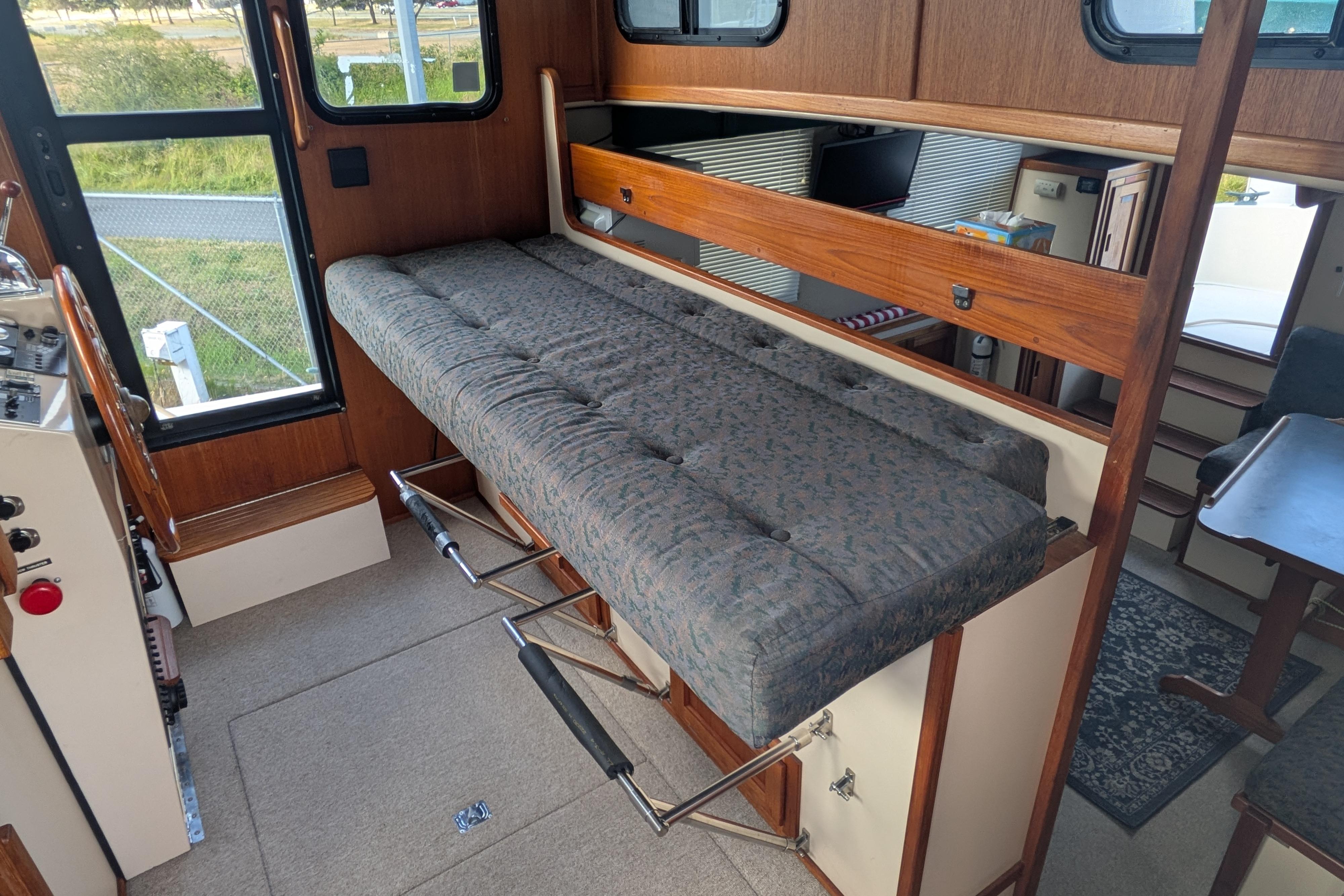 Interior of a 1998 Nordic Tug 32, featuring a fold-out cushioned bench.