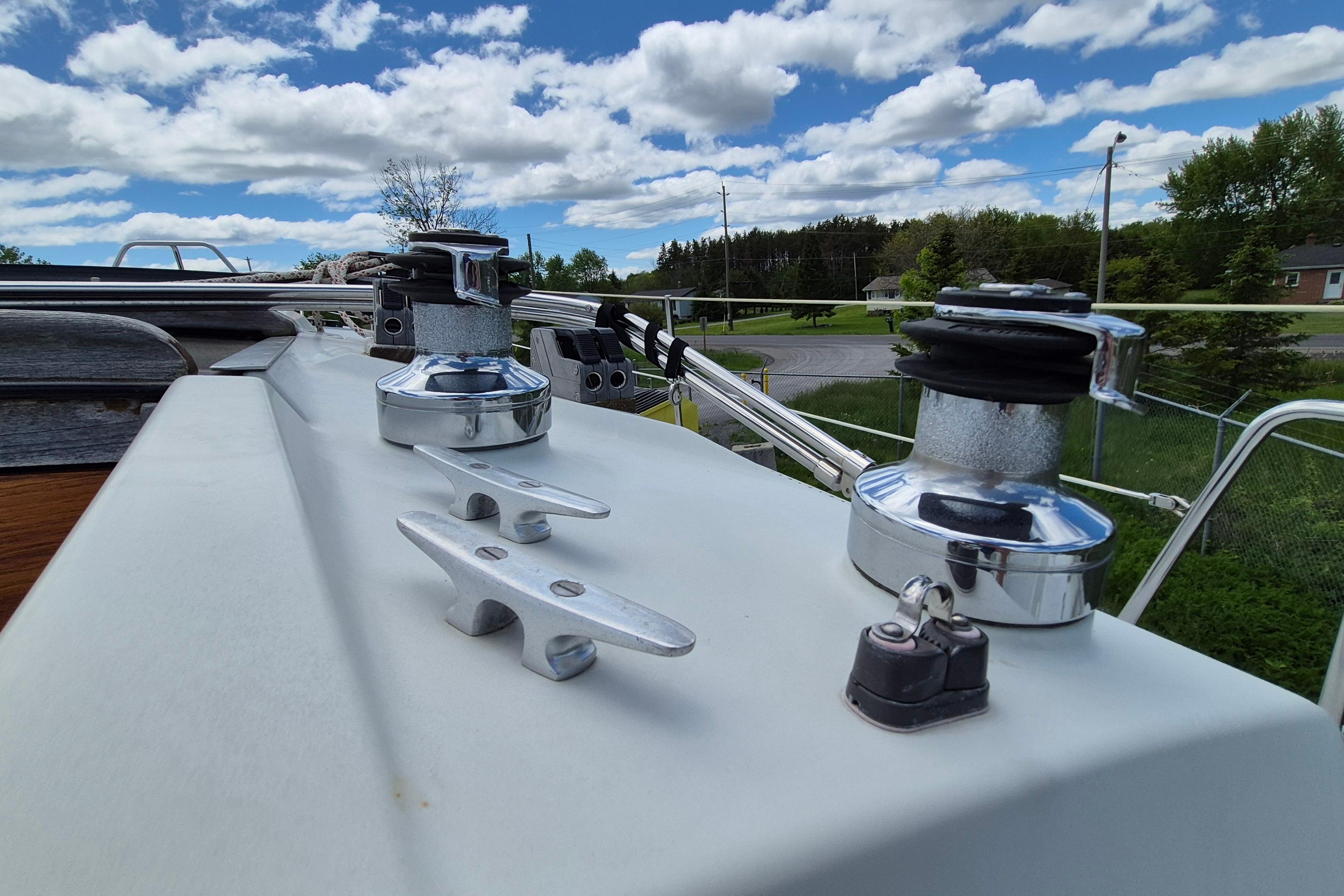 Deck view of a 1991 Ericson 38 sailboat with winches and cleats under a cloudy sky.