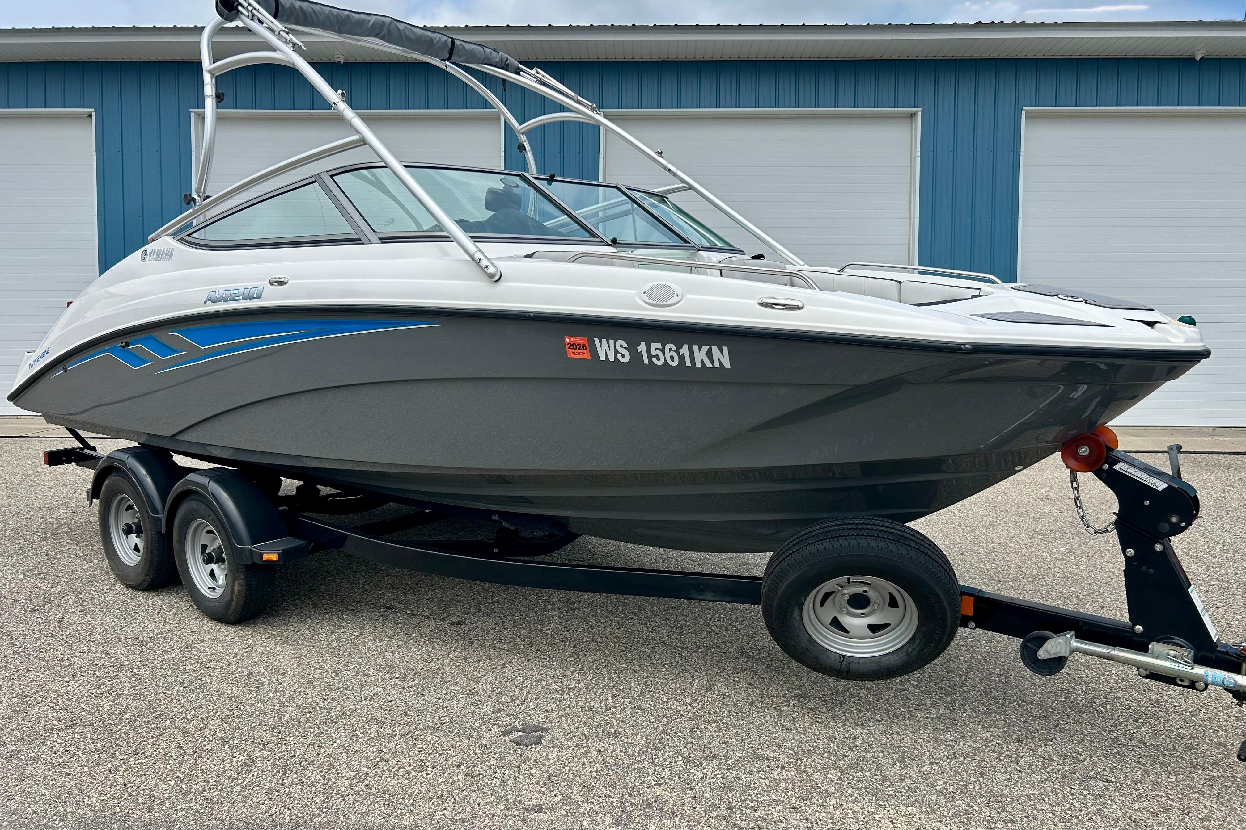 2015 Yamaha Boats AR210 on trailer, parked outside blue building.