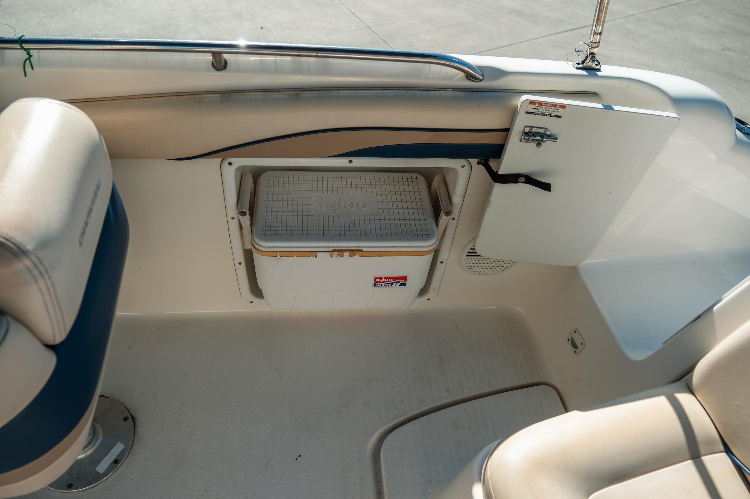 Interior of a 1998 Chaparral 232 Sunesta boat with built-in cooler storage.