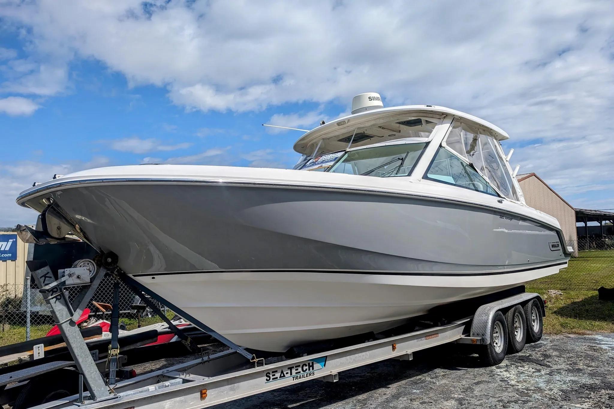 2017 Boston Whaler 320 Vantage boat on trailer under a partly cloudy sky.