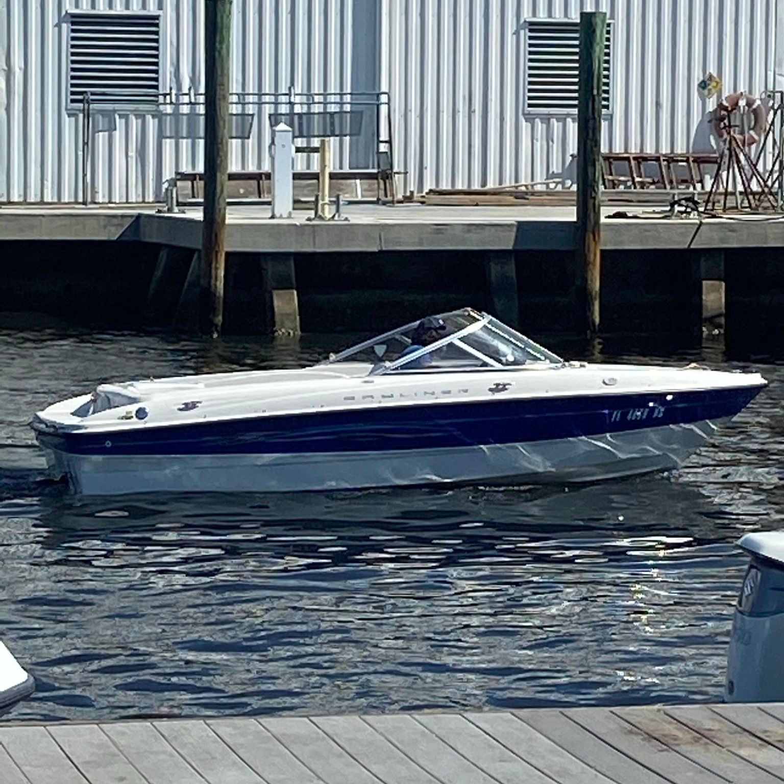 A 2006 Bayliner 185 is on the water next to a dock.