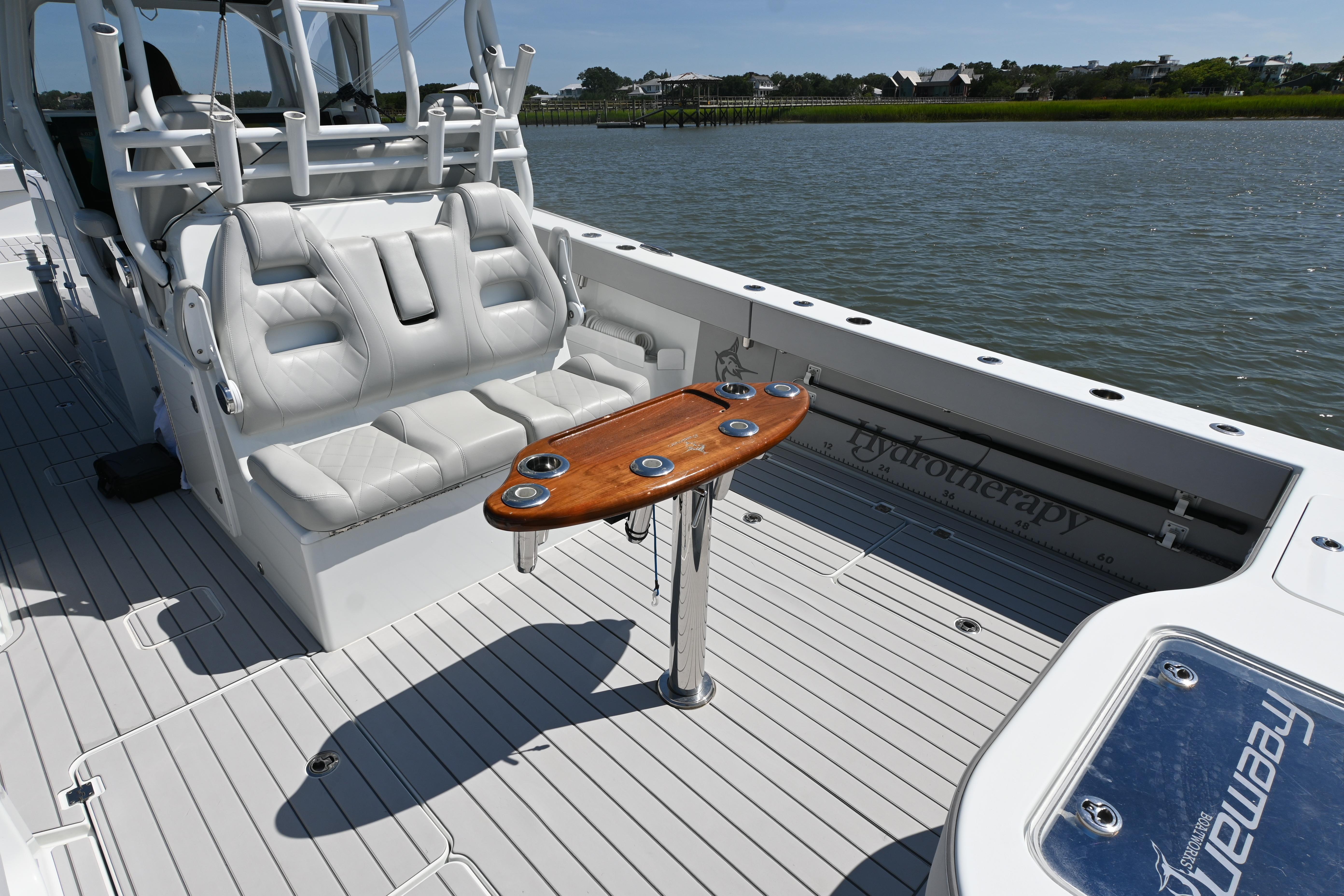 2021 Freeman 37VH boat interior with white seating and wooden table on a calm water backdrop.