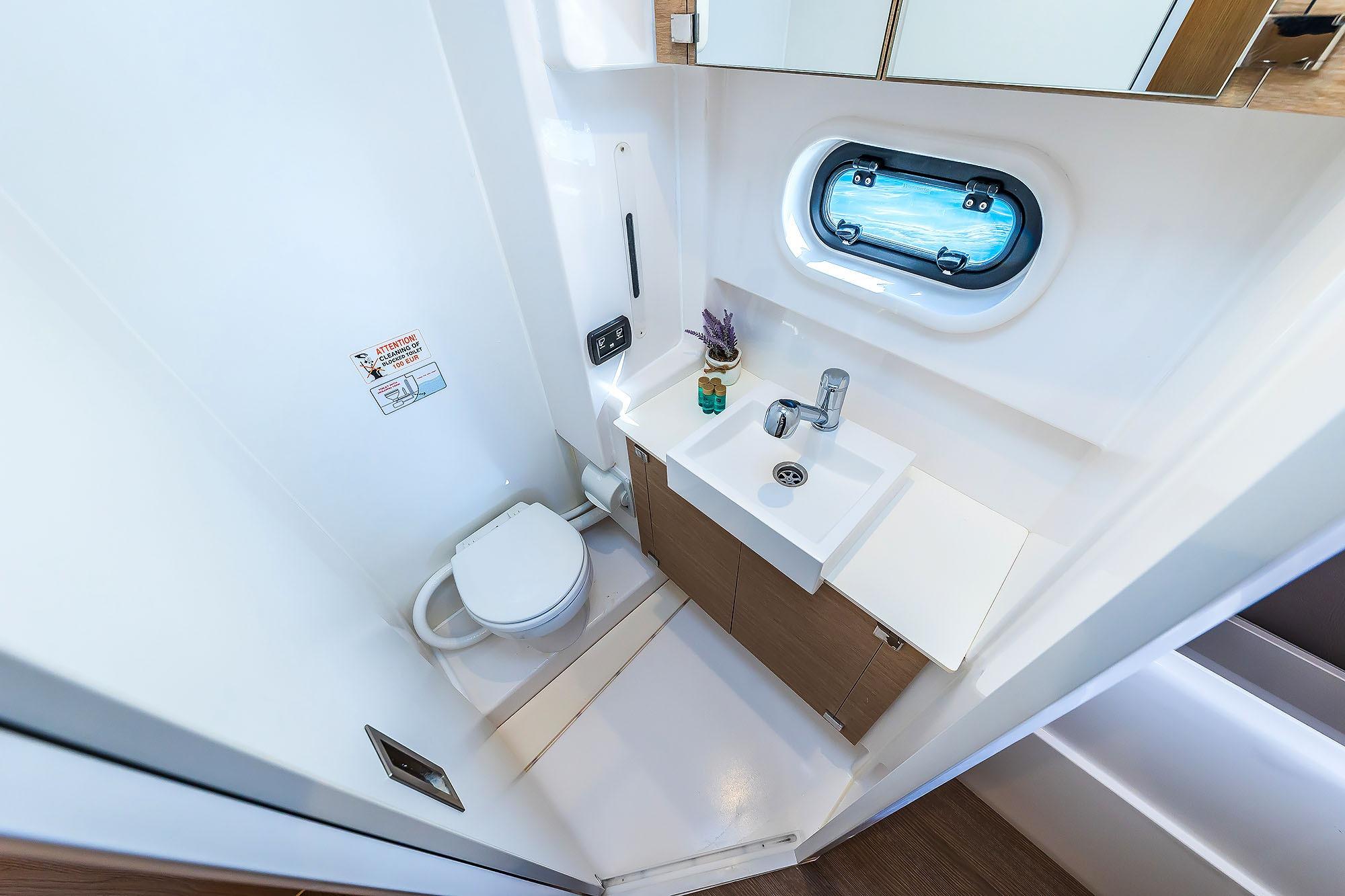 Compact bathroom in 2018 Bali 4.1 yacht with sink, toilet, and porthole window.