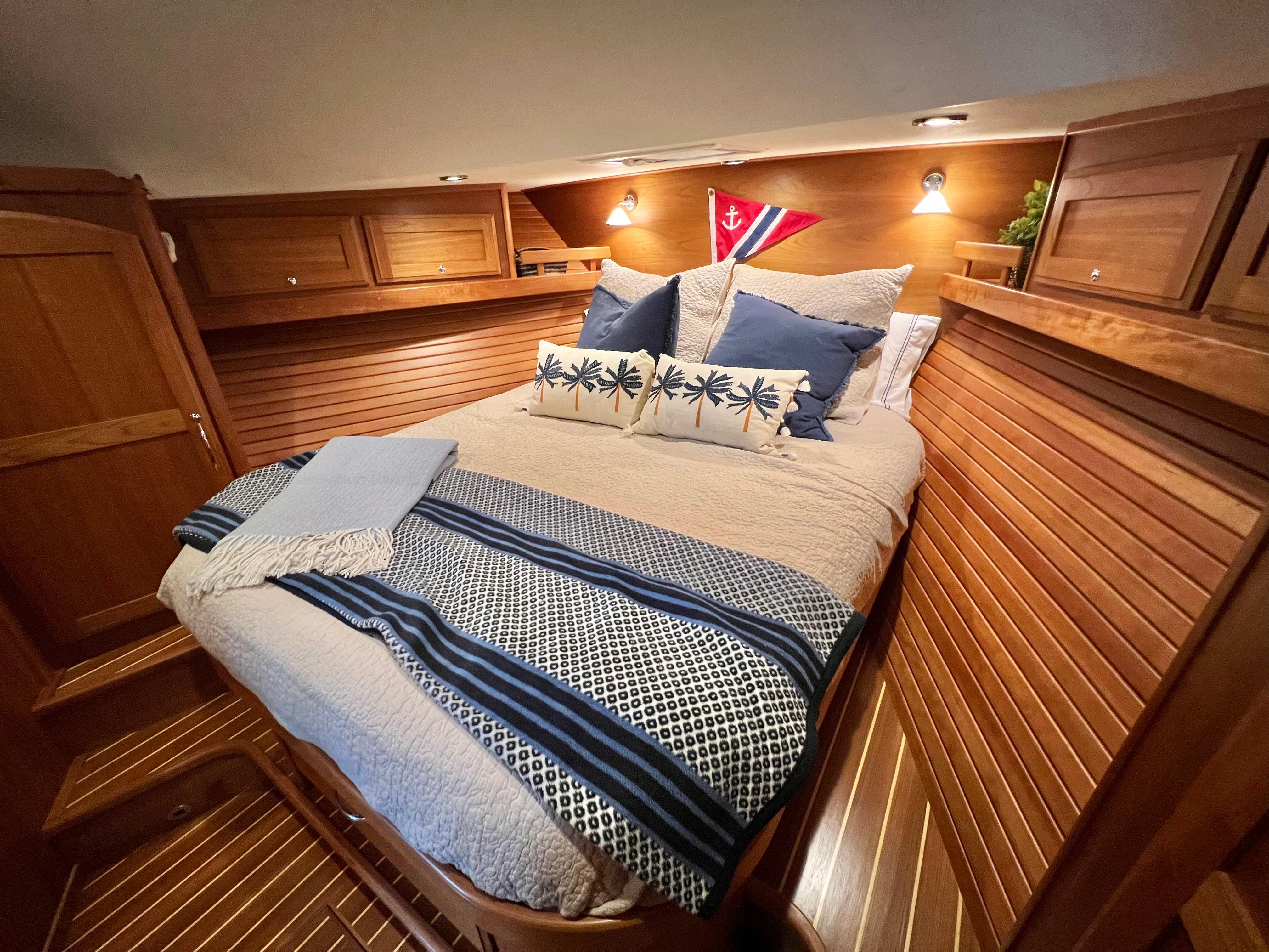 Cozy bedroom in 2017 Sabre 48 Salon Express yacht with nautical decor and wood paneling.