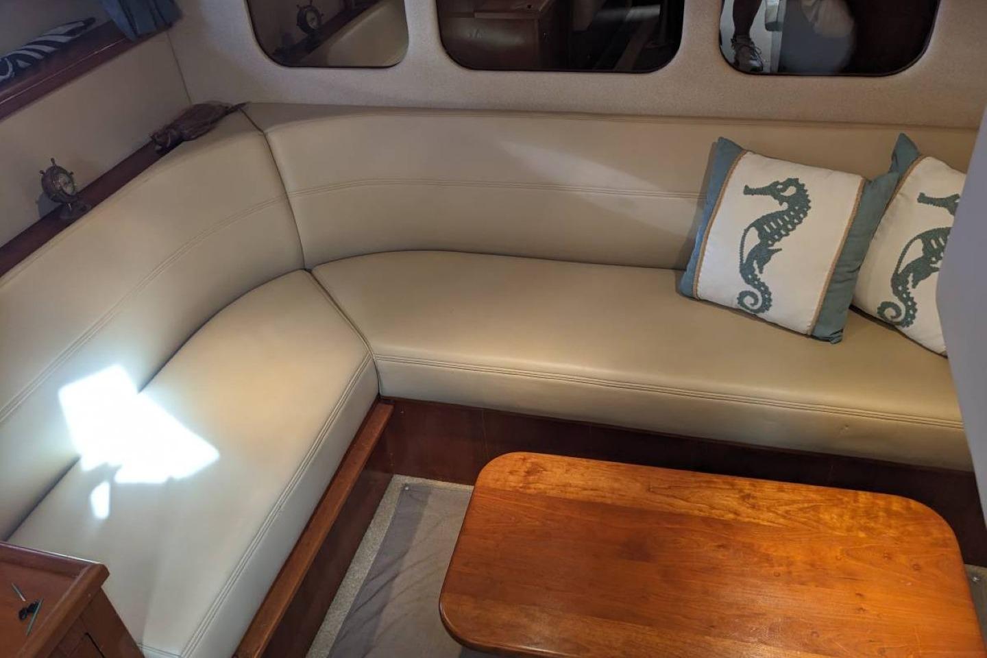 2003 Cruisers 3970 yacht interior with beige seating and seahorse-themed pillows.