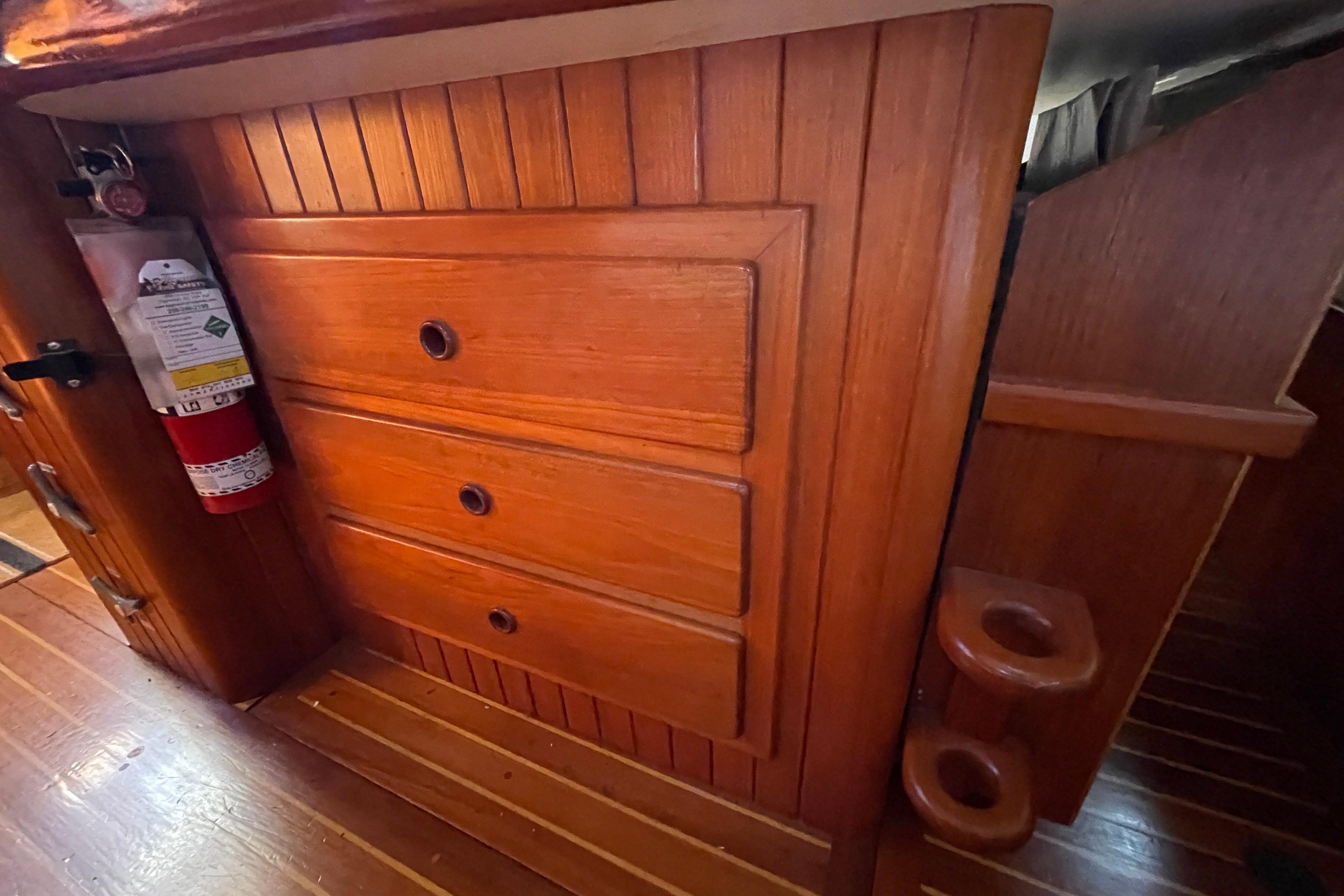 Wooden interior of 1981 Hans Christian MKII sailboat with drawers and fire extinguisher.