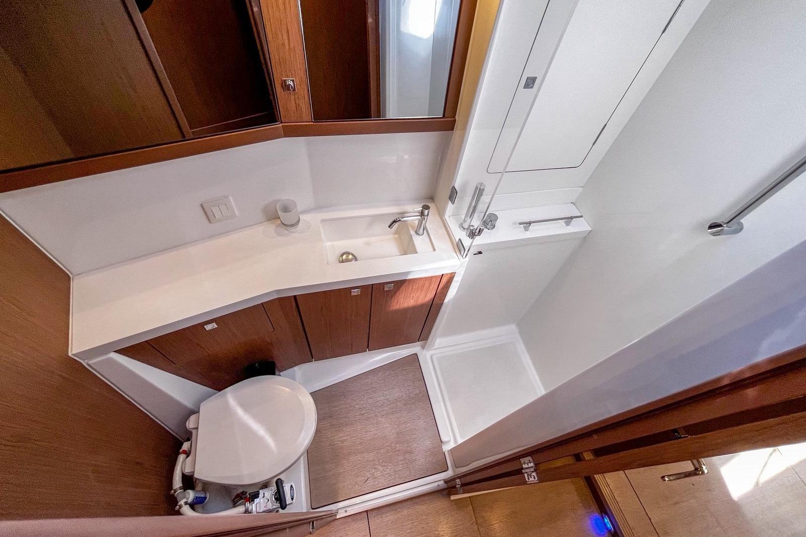 2018 Beneteau Sense 51 yacht bathroom with modern fixtures and wooden cabinetry.