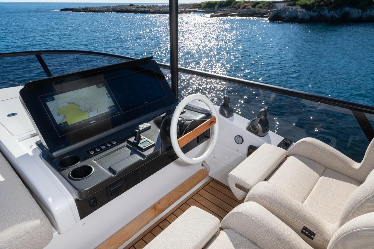 Helm of 2025 Azimut Fly 62 yacht with navigation display, overlooking ocean.
