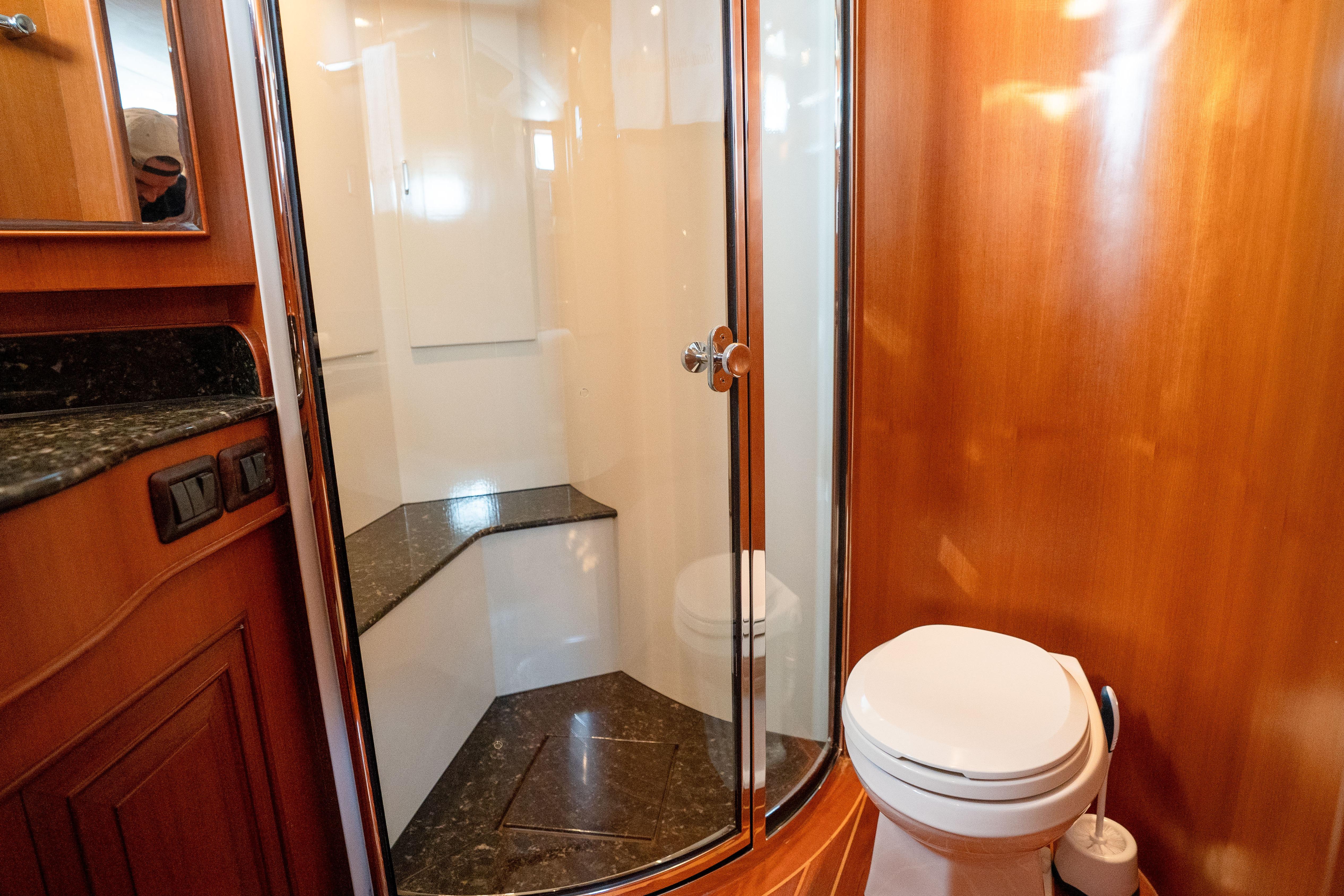 Luxurious bathroom in 2006 Fleming 75 yacht with wood paneling and modern fixtures.