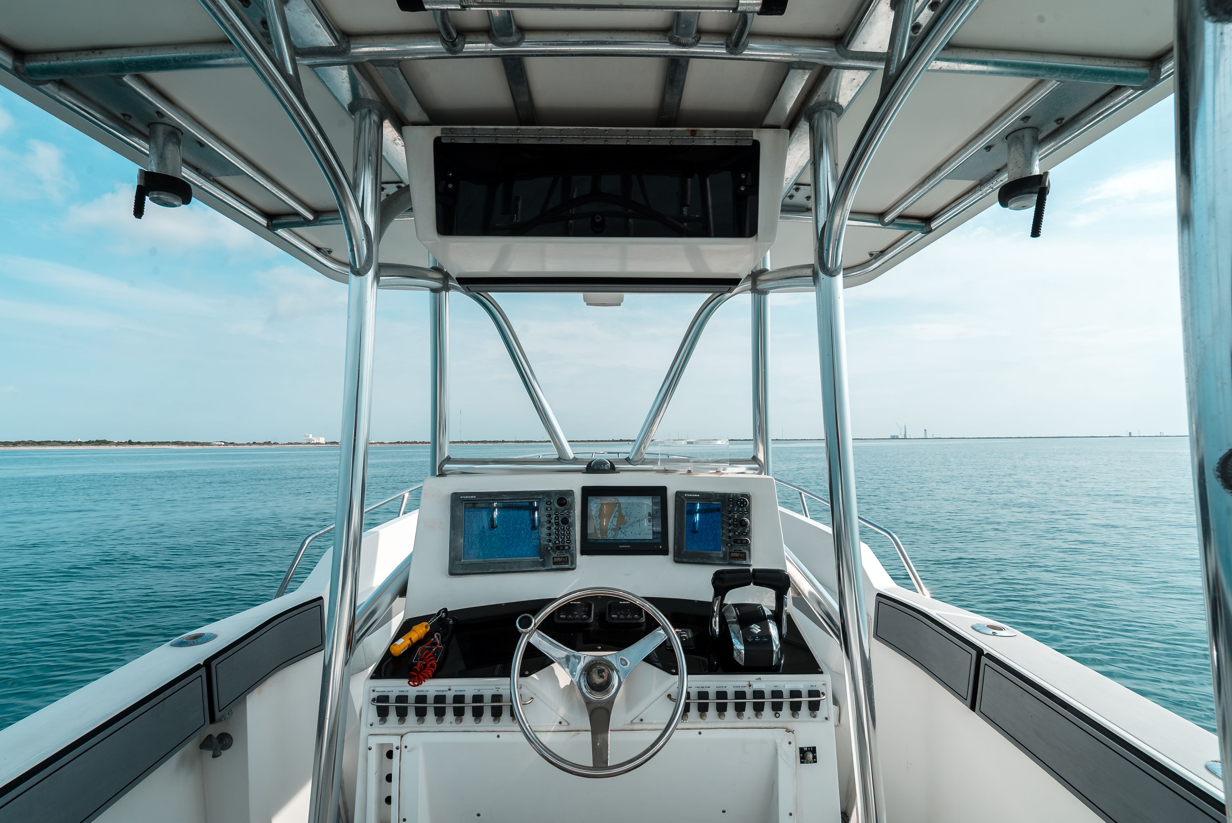 The cockpit of a 2006 Tempest Offshore 40 with steering and navigation screens.