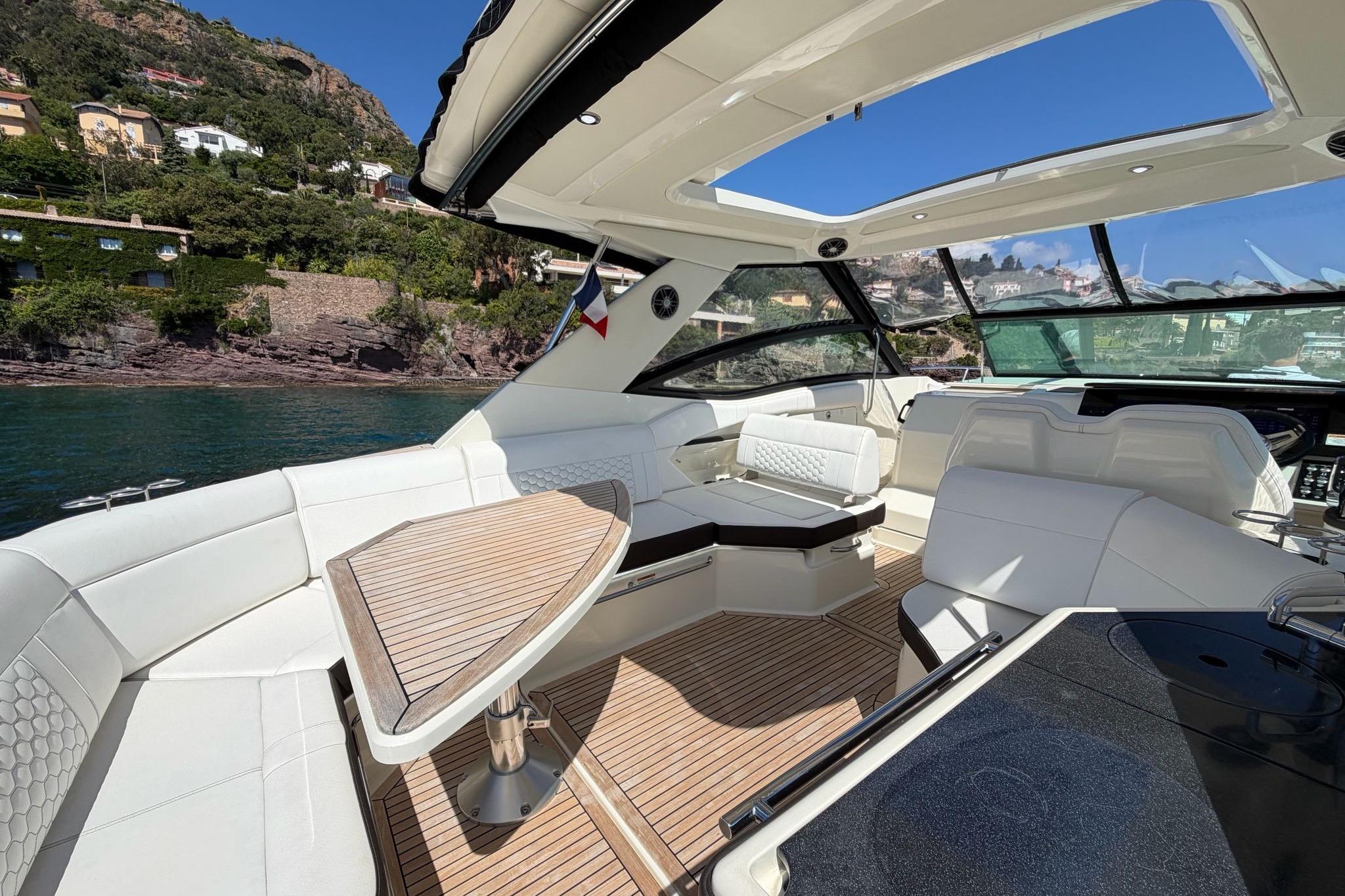 2022 Sea Ray Sundancer 320 yacht interior with luxurious seating and scenic coastal view.