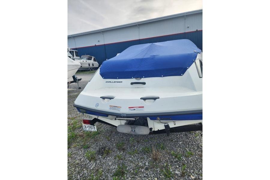 2012 Sea-Doo Sport Boats 180 Challenger with blue cover, parked on gravel.