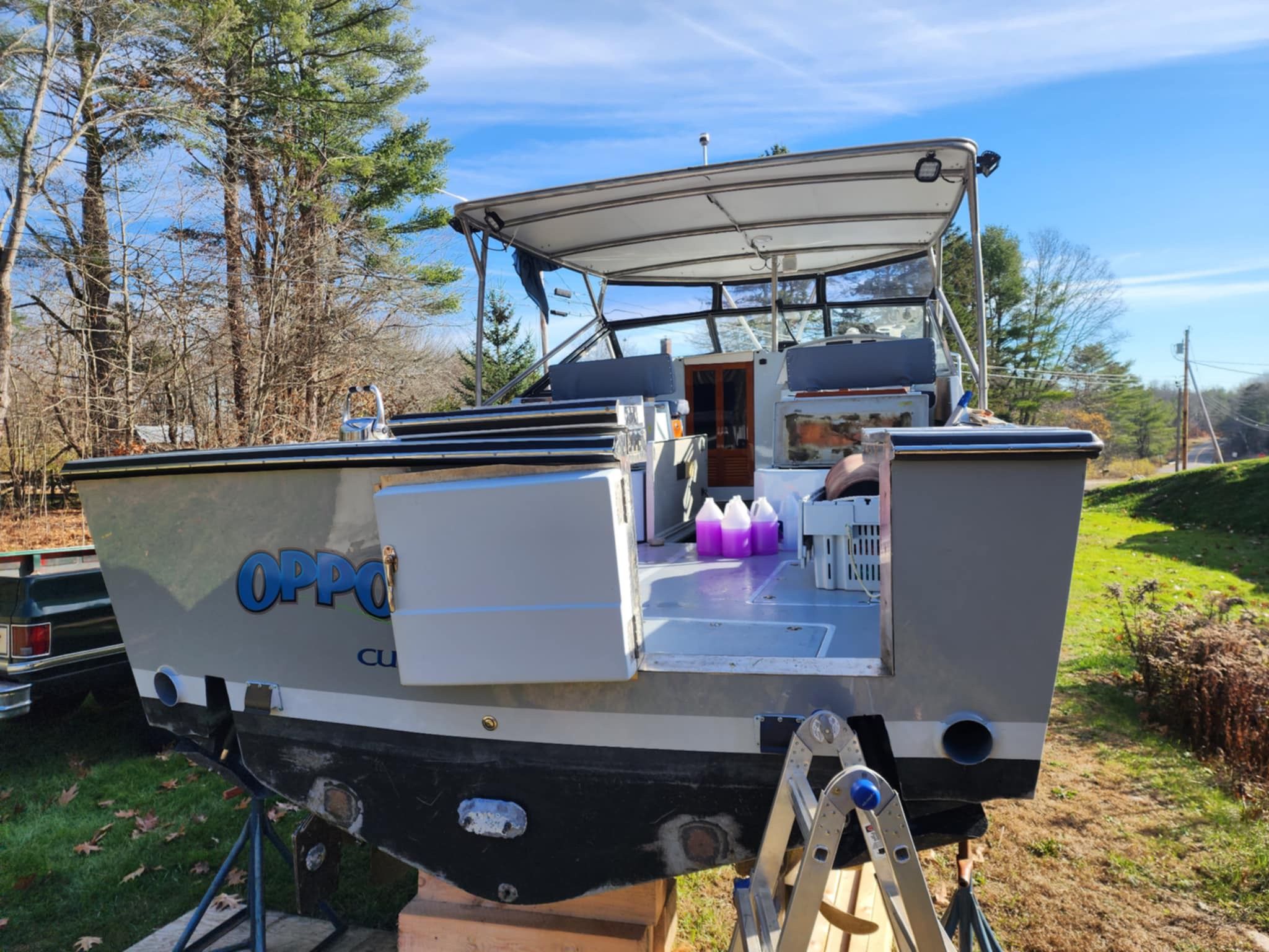 1989 Black Watch Custom 35 boat parked on grass.