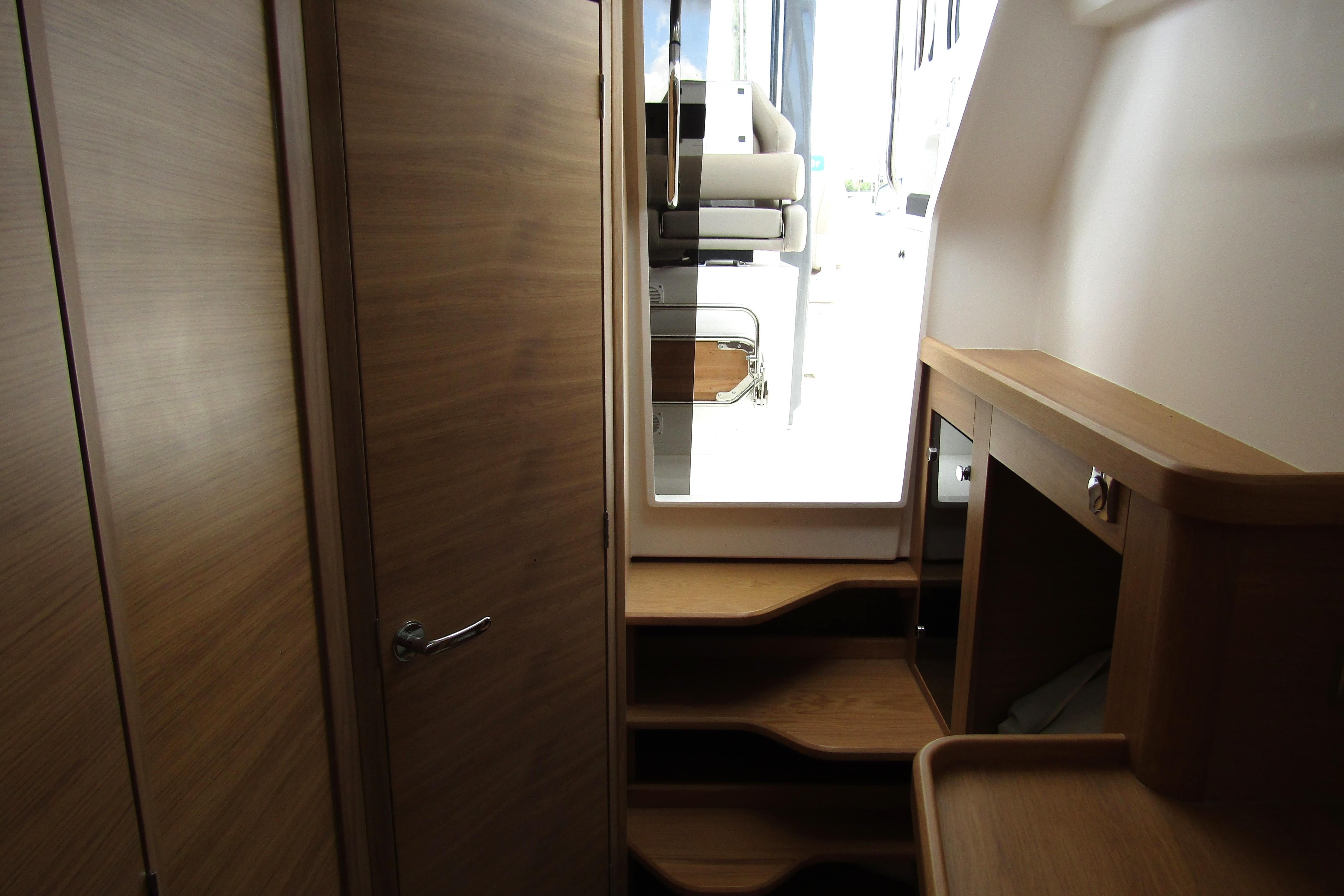 Interior view of 2025 Nimbus Tender 11 yacht with wooden cabinetry and steps.