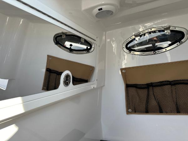 Interior cabin of 2025 Southport 33 DC boat with portholes and storage net.