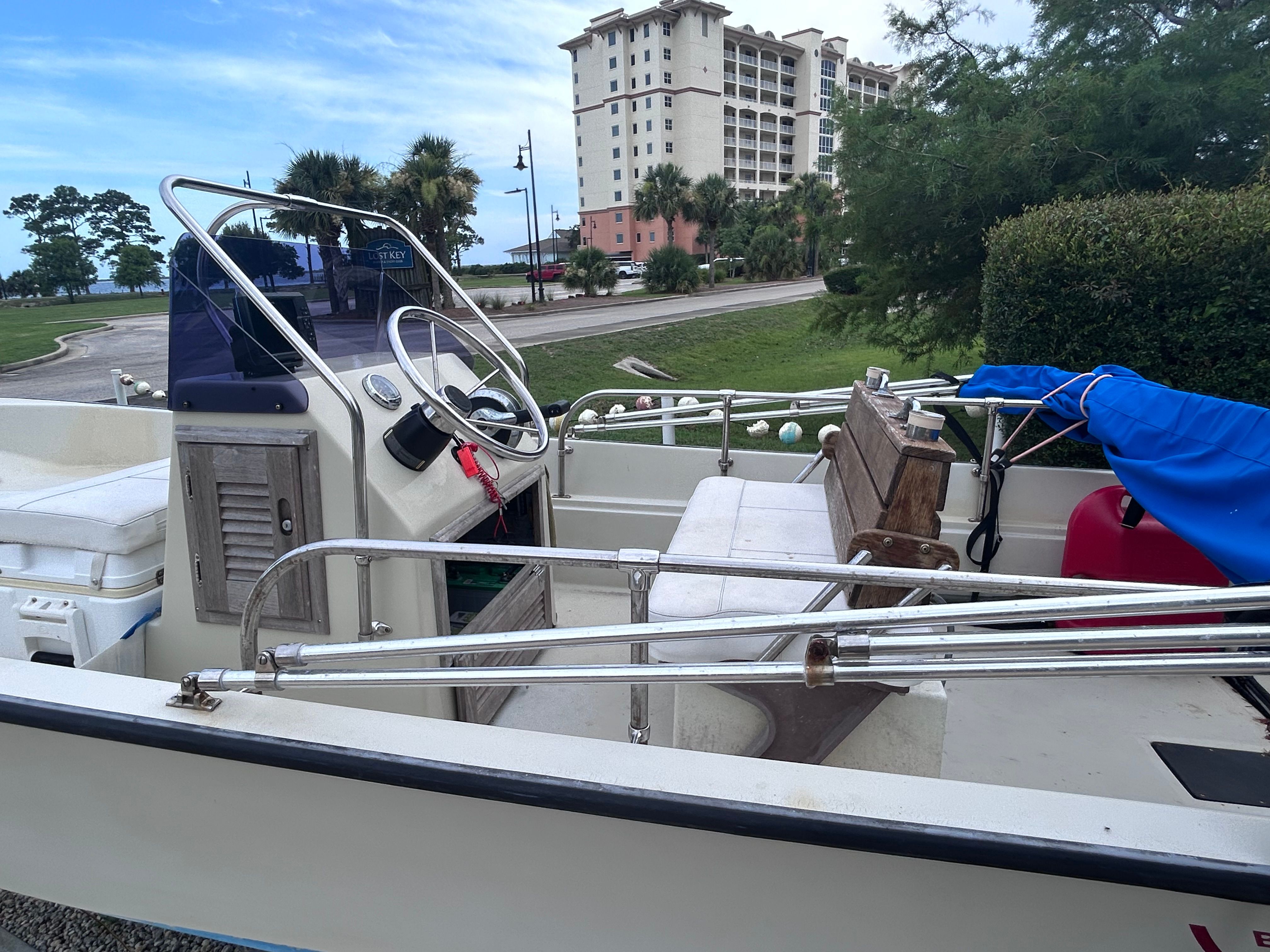 A 1984 Boston Whaler MONTAUK on land. It features white seating and a blue cover.