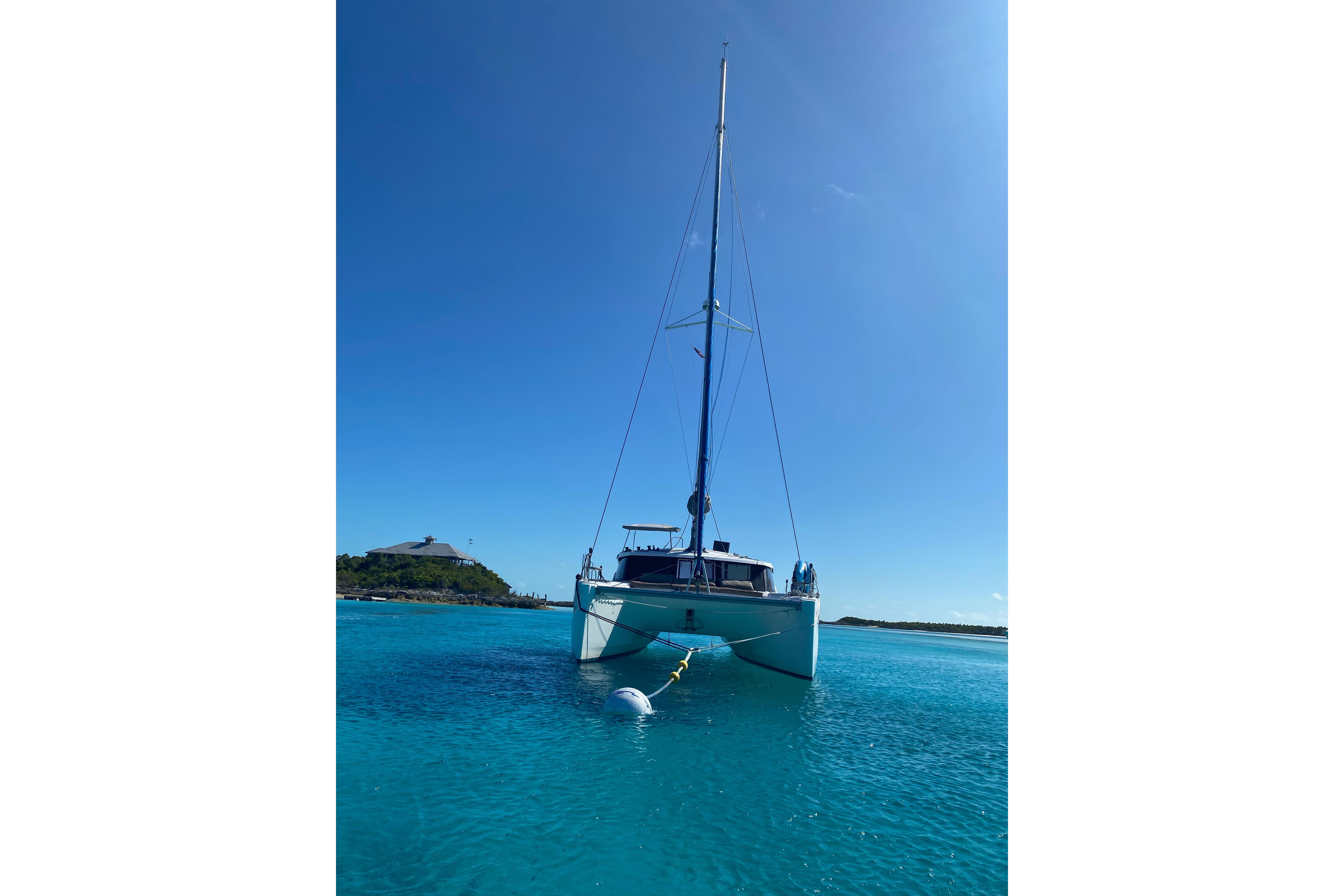 2018 Fountaine Pajot Lucia 40 catamaran anchored in clear blue water.