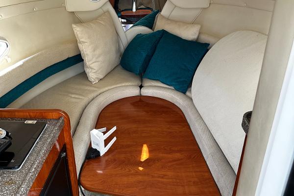 2004 Rinker Fiesta Vee 250 cabin interior with cozy seating and wooden table.