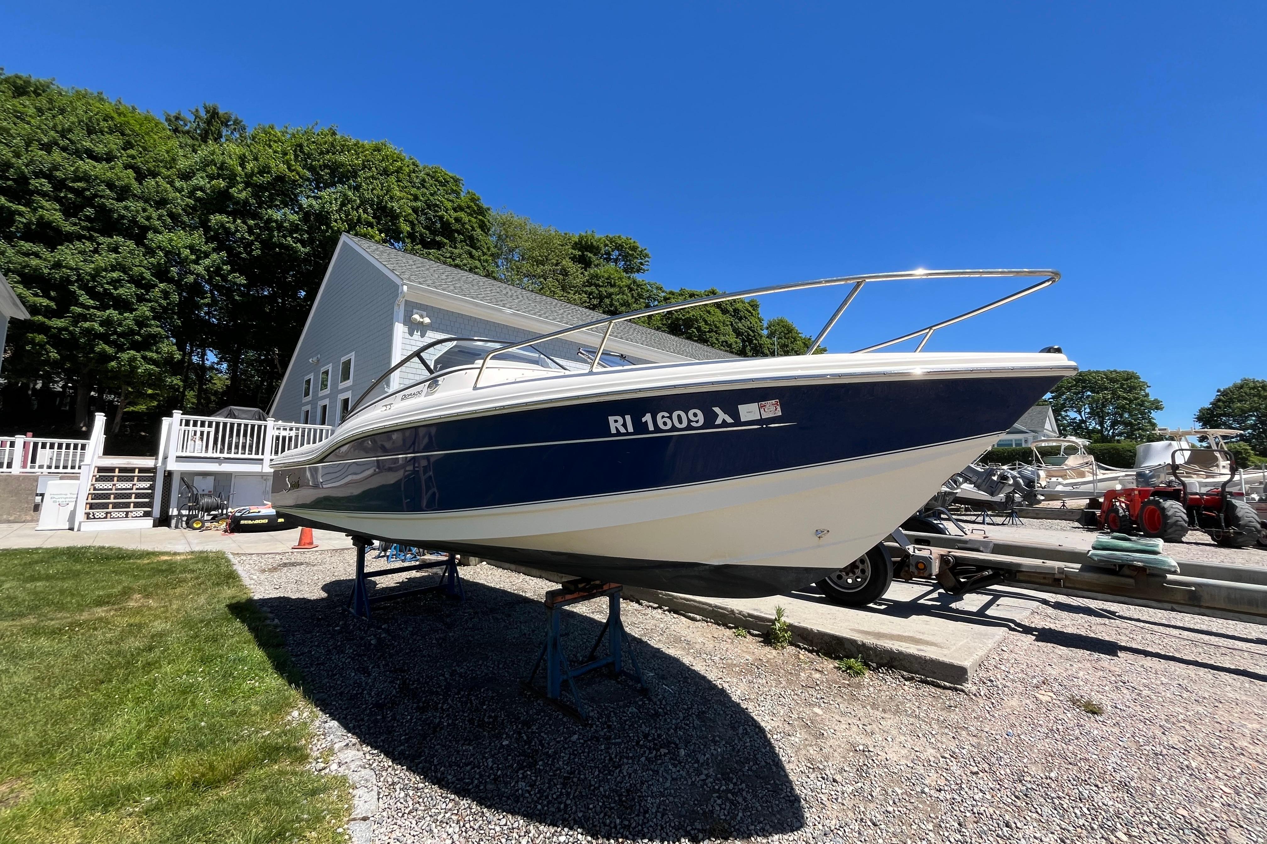 2017 Scout 210 Dorado boat on trailer, parked outdoors under clear blue sky.