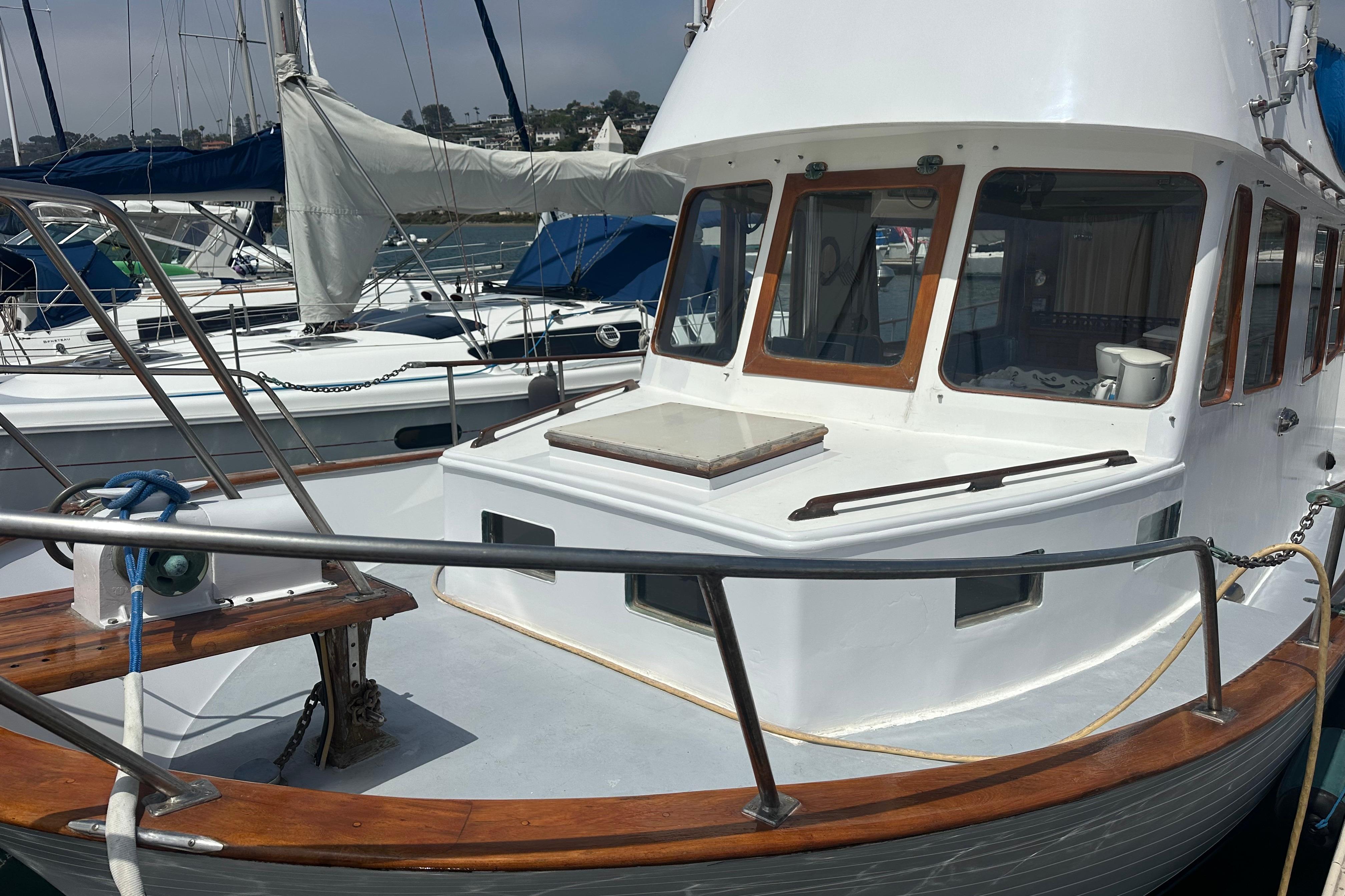 1973 CHB 33 boat docked at marina, featuring wooden accents and large windows.
